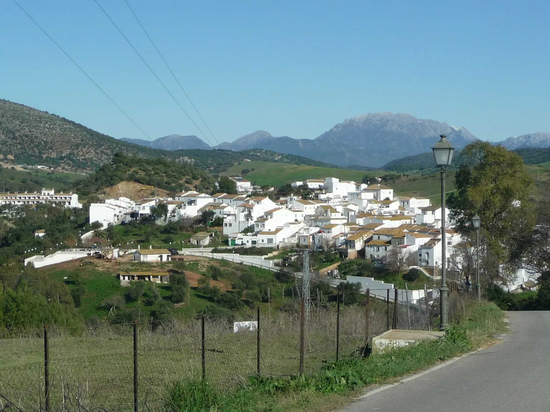 Casas blancas de Algar en una loma, con la sierra al fondo y cielo azul