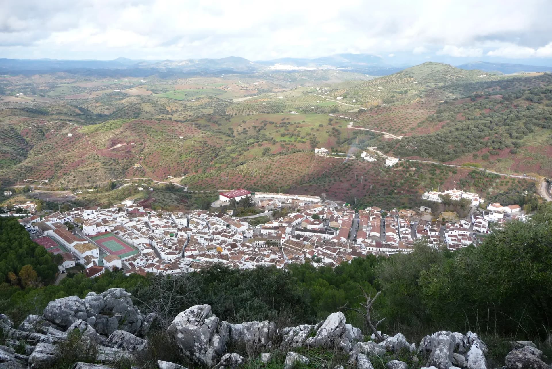 Vista aérea de El Gastor con sus casas blancas escalonadas en la ladera y los campos de olivar alrededor
