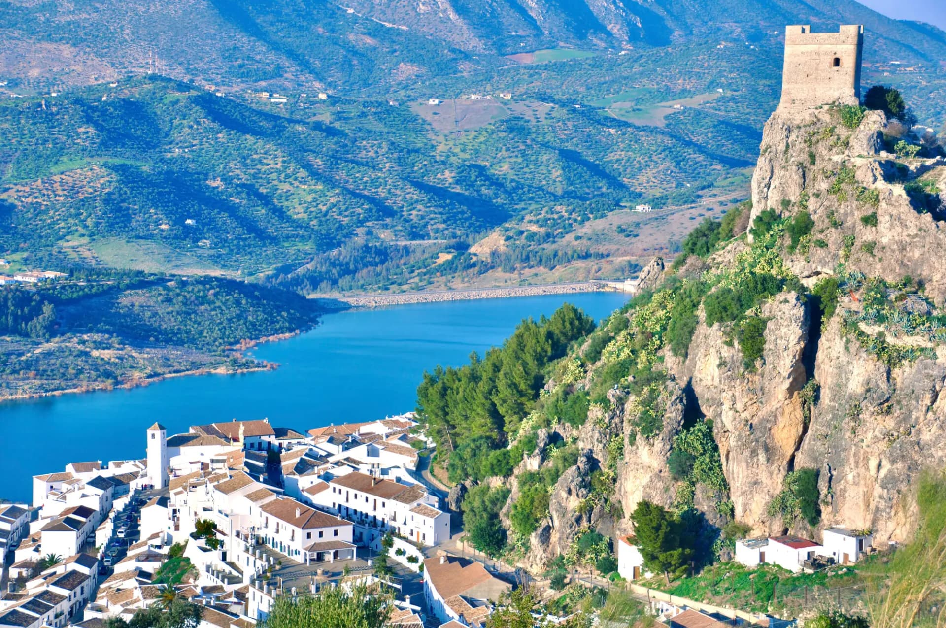 Zahara de la Sierra con su castillo sobre la roca, las casas blancas debajo y el embalse al fondo