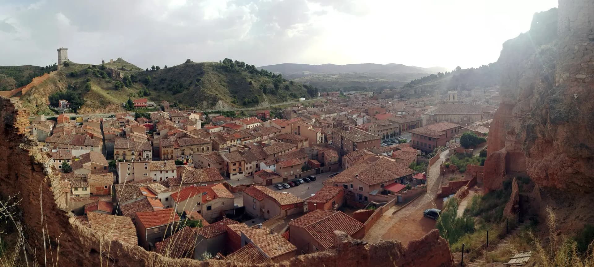 Panorámica de los tejados de Daroca entre cerros, con la muralla al fondo