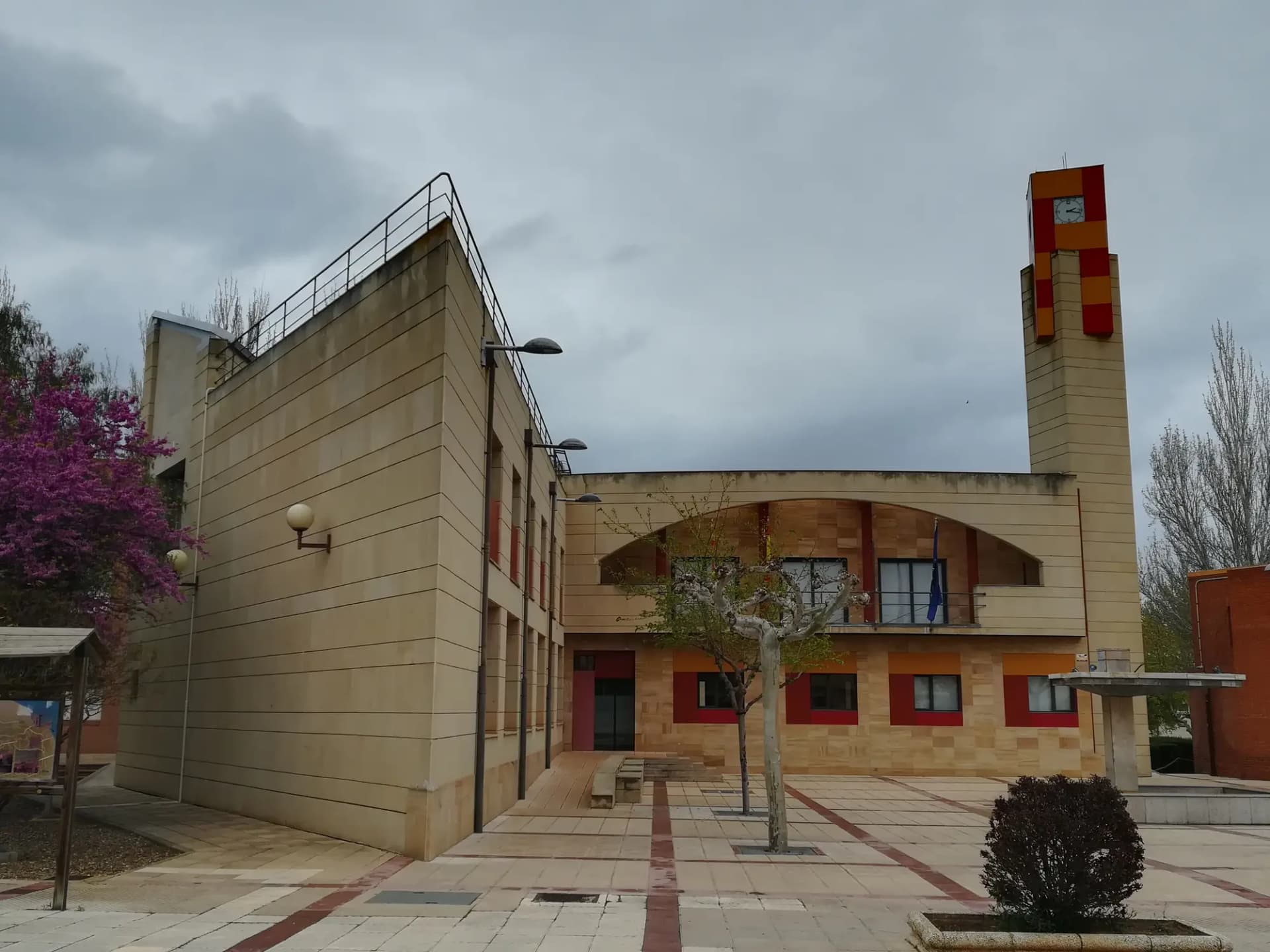 Plaza de Figueruelas con edificio de ladrillo y una torre rojiza