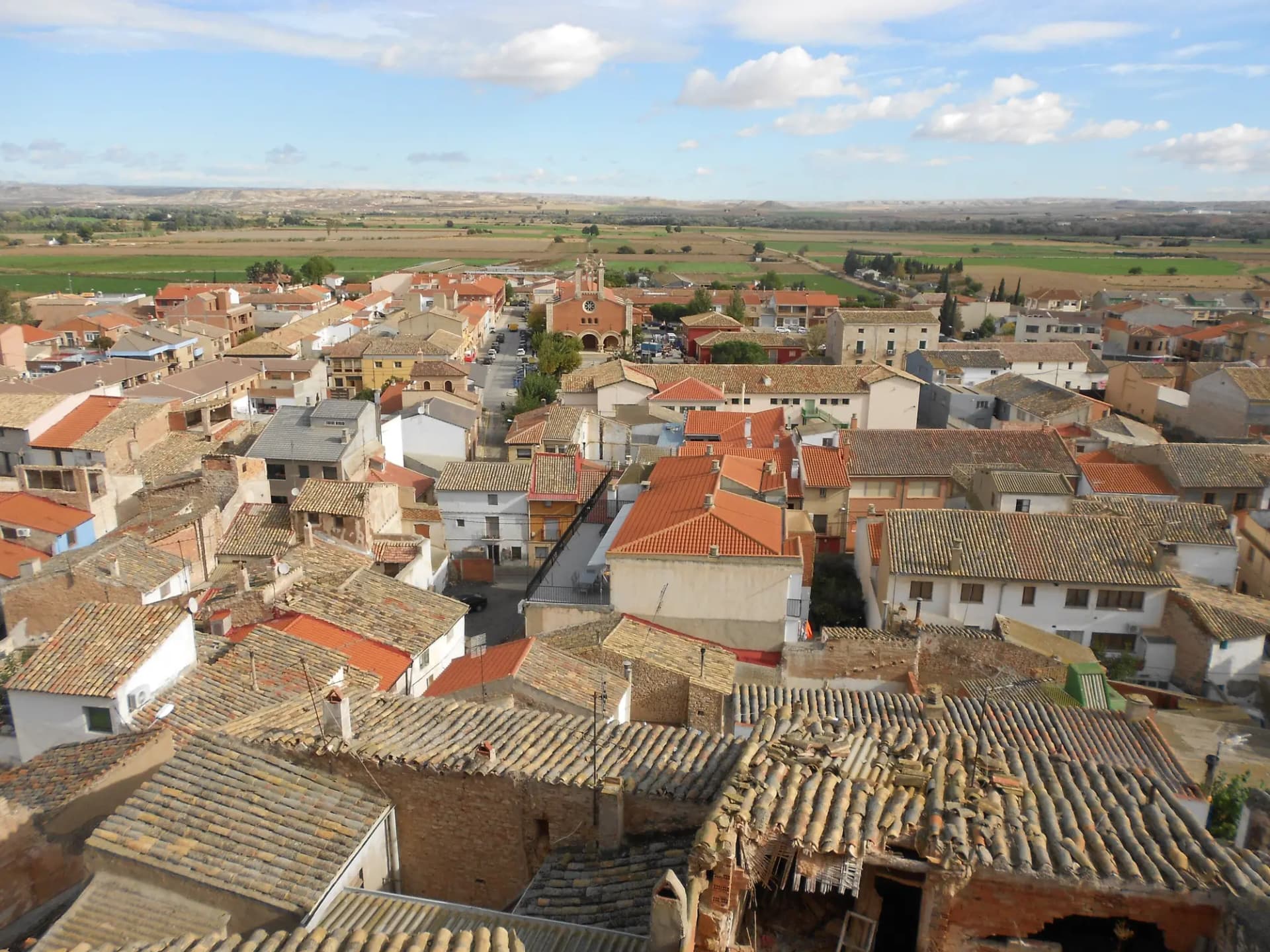 Vista aérea de los tejados rojizos de Quinto con la llanura del Ebro al fondo