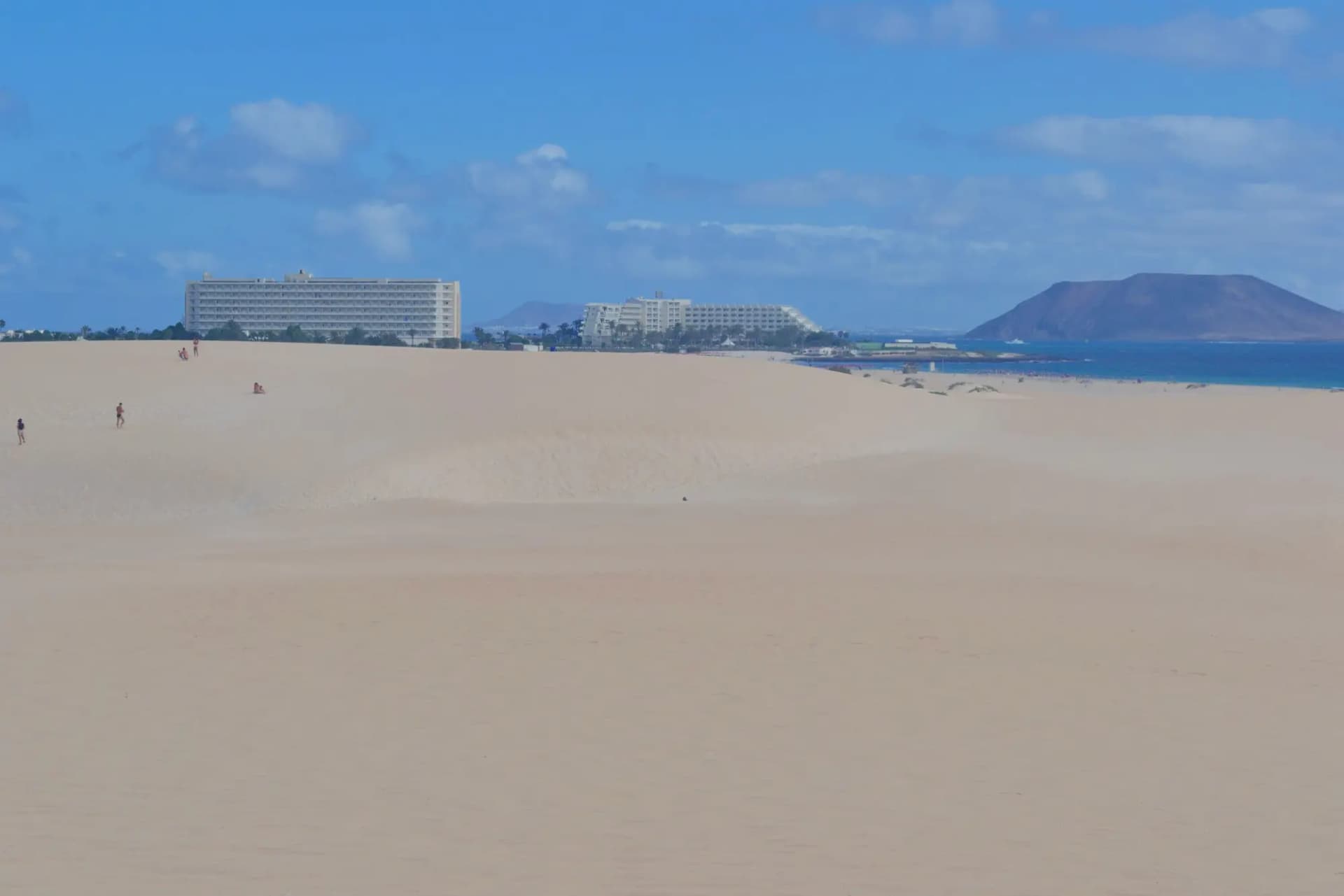 Dunas de arena blanca de Corralejo con el mar y la isla de Lobos al fondo