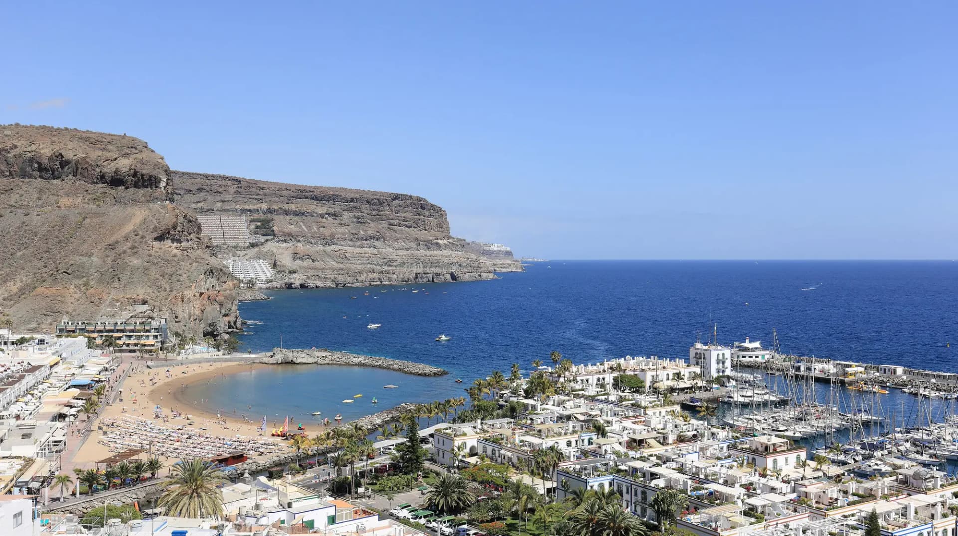 Vista del Puerto de Mogán con la playa, el puerto deportivo y los acantilados