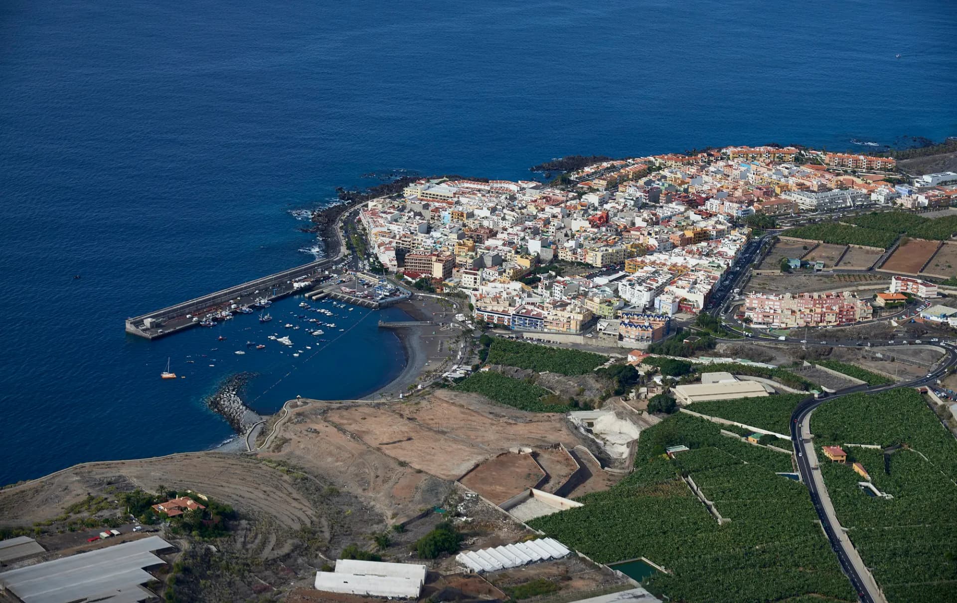 Vista aérea de Playa San Juan con su puerto, el pueblo junto al mar y plataneras alrededor