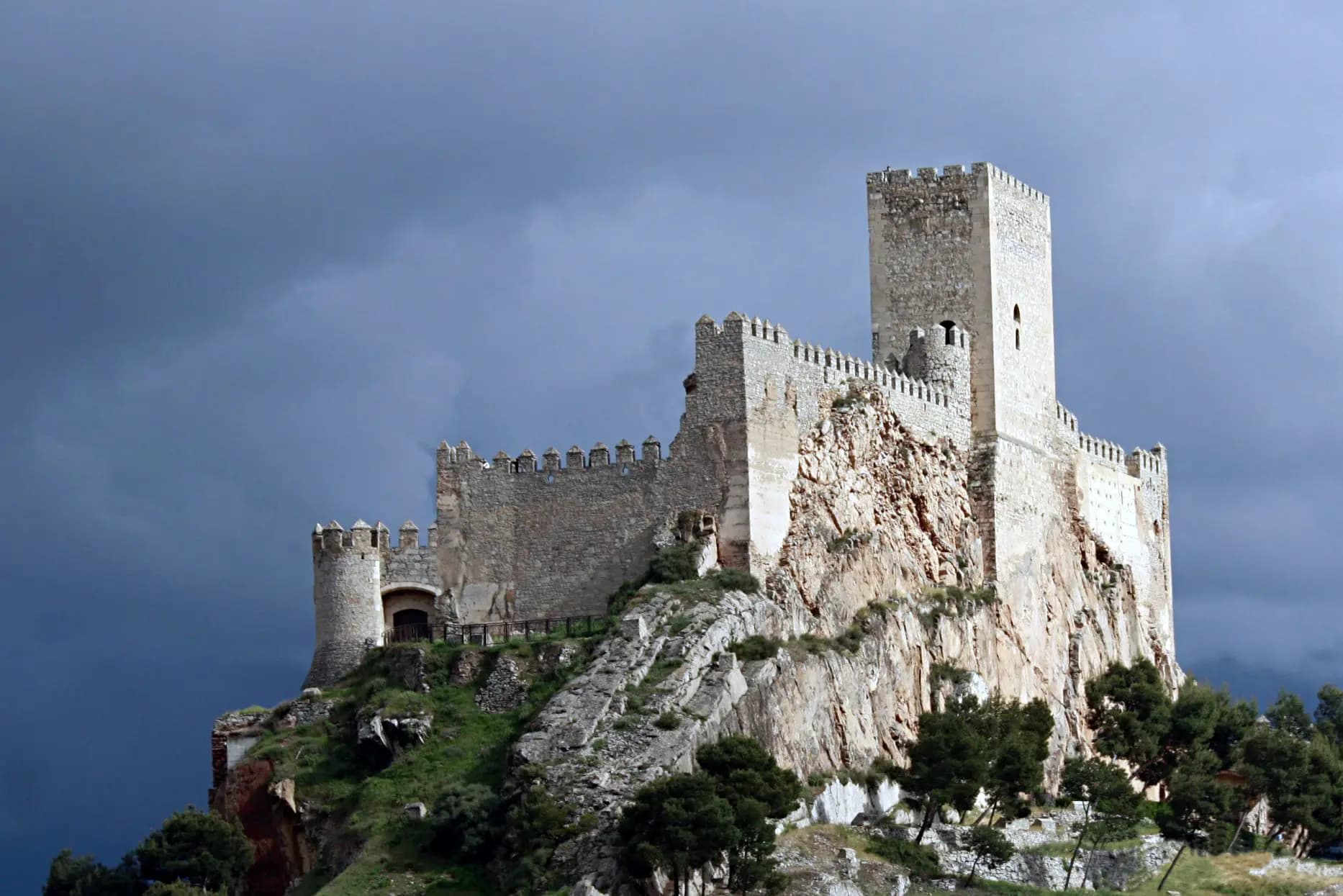 Castillo de Almansa sobre su peñón rocoso, con la torre del homenaje, bajo un cielo de tormenta