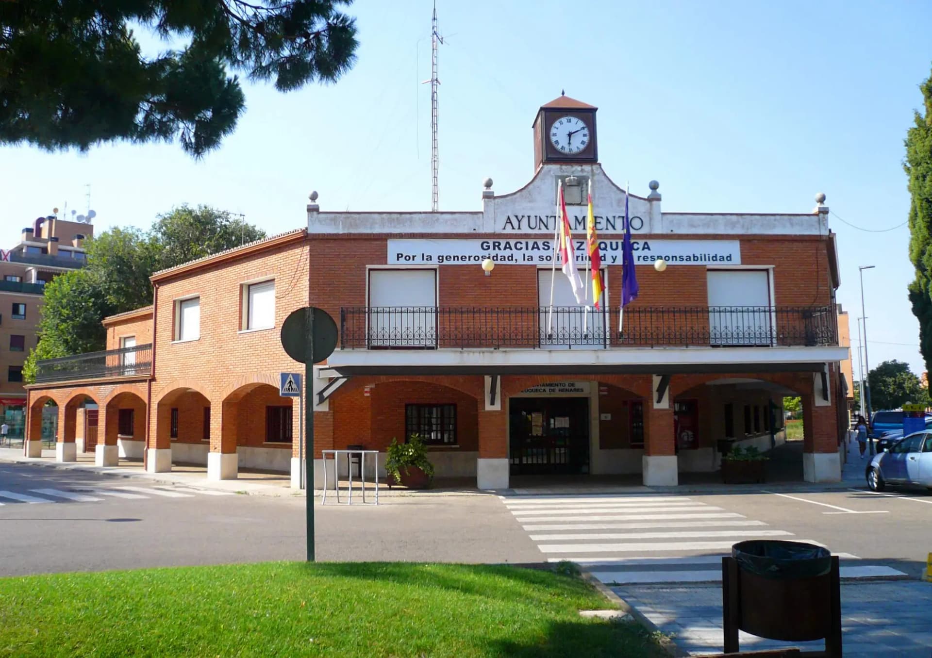 Edificio de ladrillo del Ayuntamiento de Azuqueca de Henares, con soportales y reloj en lo alto