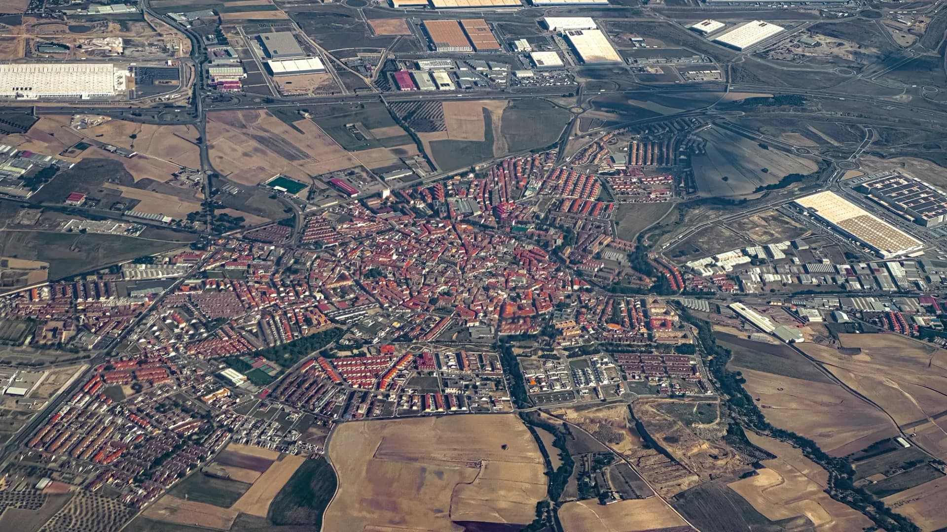 Vista aérea de Illescas con el casco urbano rodeado de naves industriales y campos de La Sagra