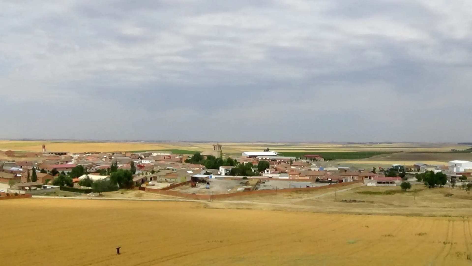 Vista aérea de Bobadilla del Campo, con la torre de la iglesia sobre un mar de cereal