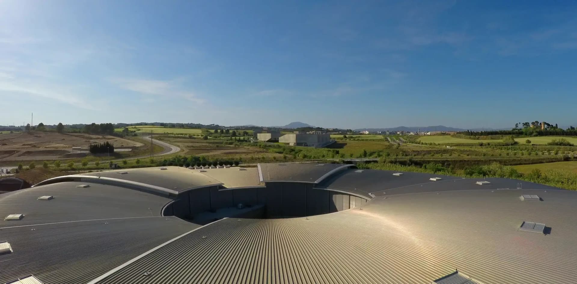 Cubierta circular del sincrotrón ALBA con los campos y el parque científico del Vallès alrededor