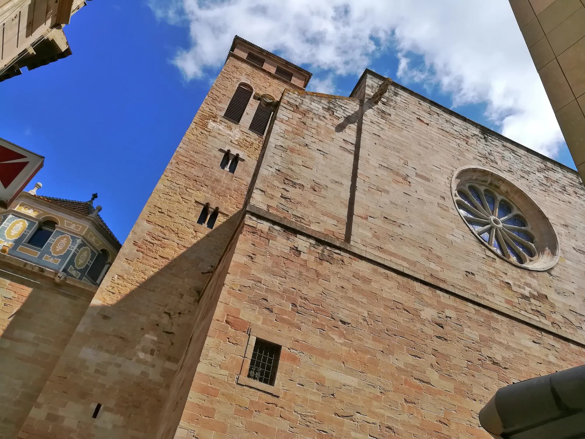 Fachada de piedra de la basílica de Santa Maria de Igualada con su rosetón y el campanario