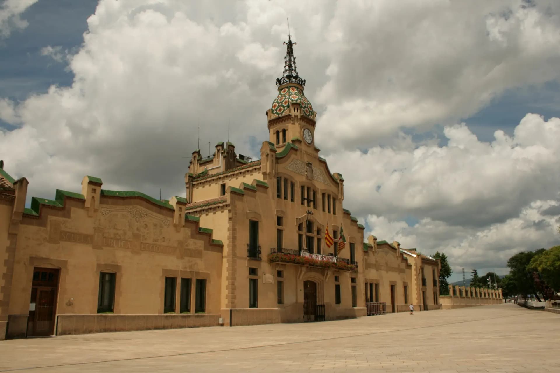 Edificio modernista del Ayuntamiento de Les Franqueses del Vallès con su torre central y nubes de tormenta