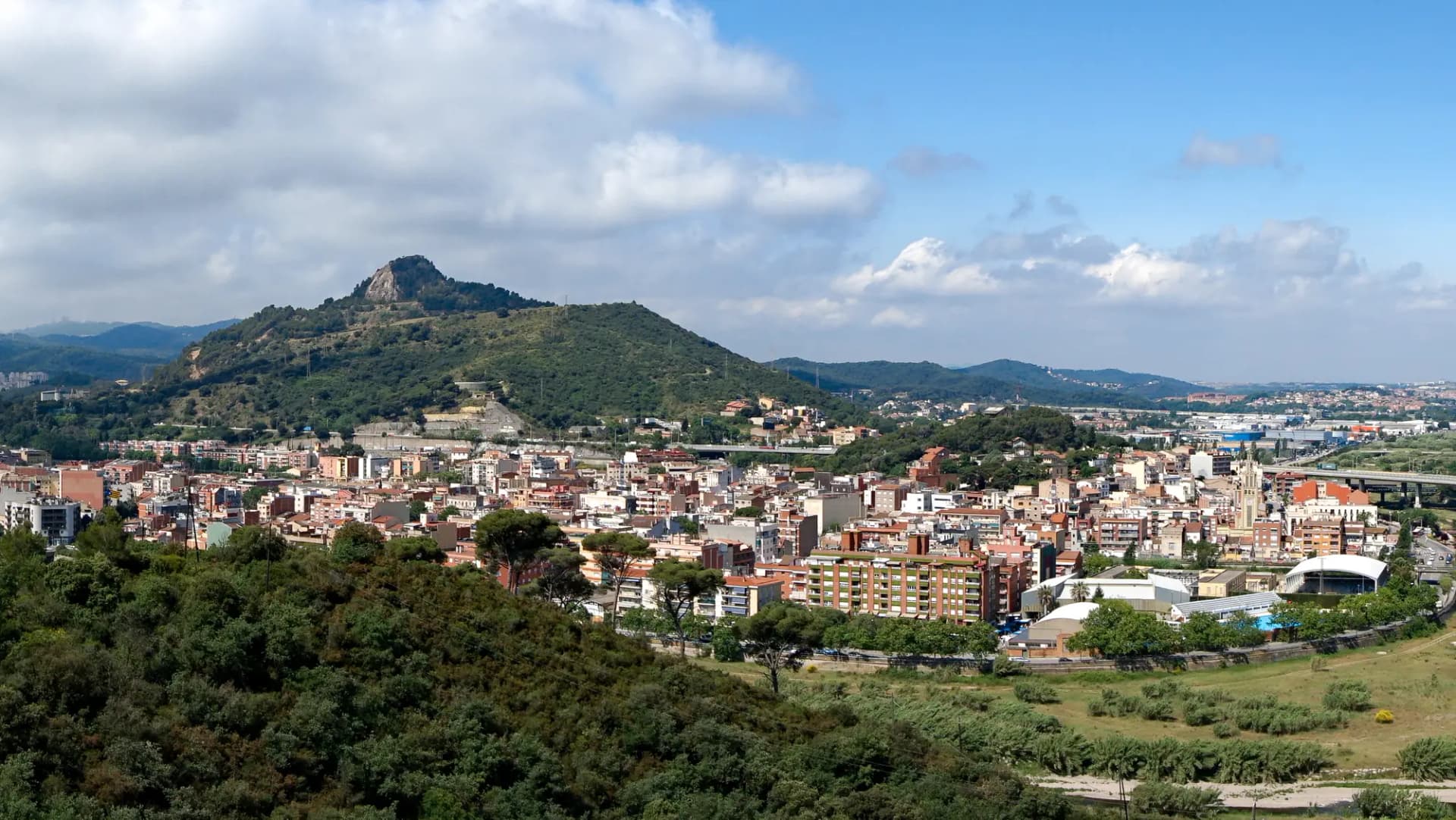 Panorámica de Montcada i Reixac con sus barrios al pie del turó y las montañas al fondo