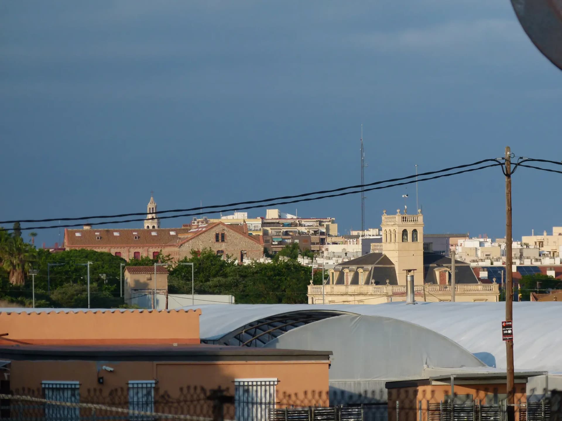 Vista de Premià de Mar con campanarios y tejados del pueblo bajo un cielo nublado