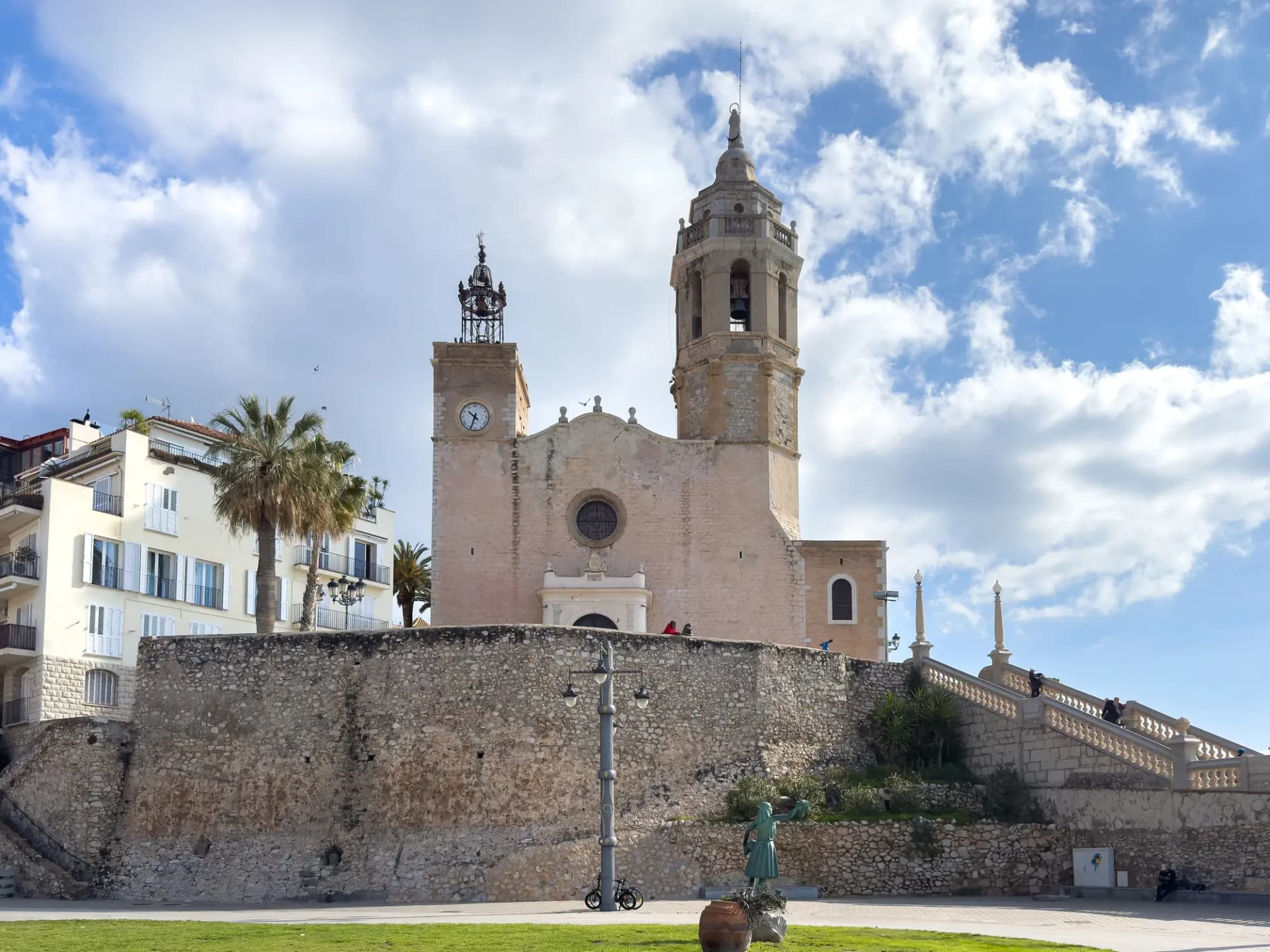 Iglesia de Sant Bartomeu i Santa Tecla de Sitges sobre la muralla, con palmeras delante