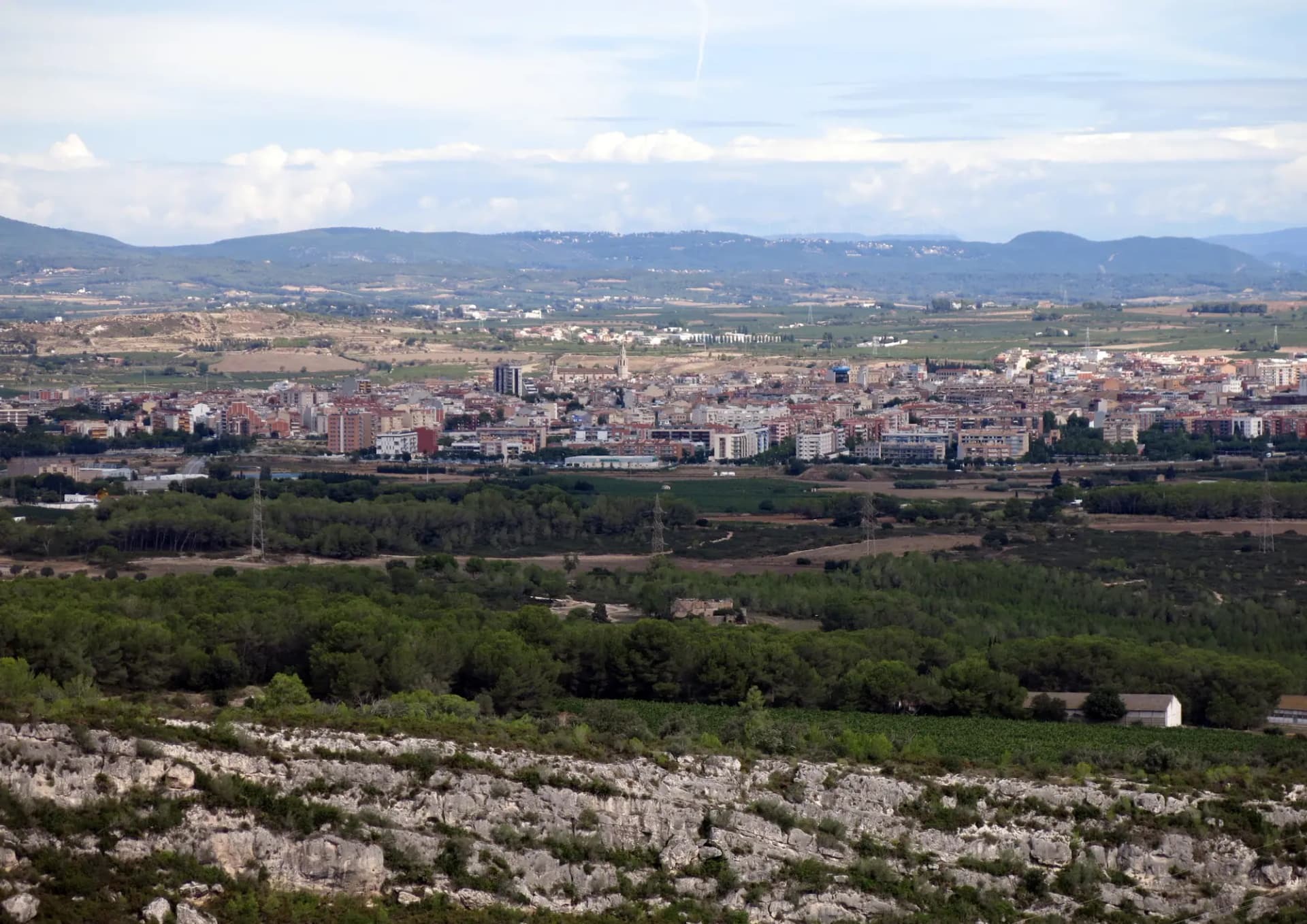Vilafranca del Penedès vista desde Olèrdola, con la ciudad en el llano rodeada de viñedos y montañas al fondo