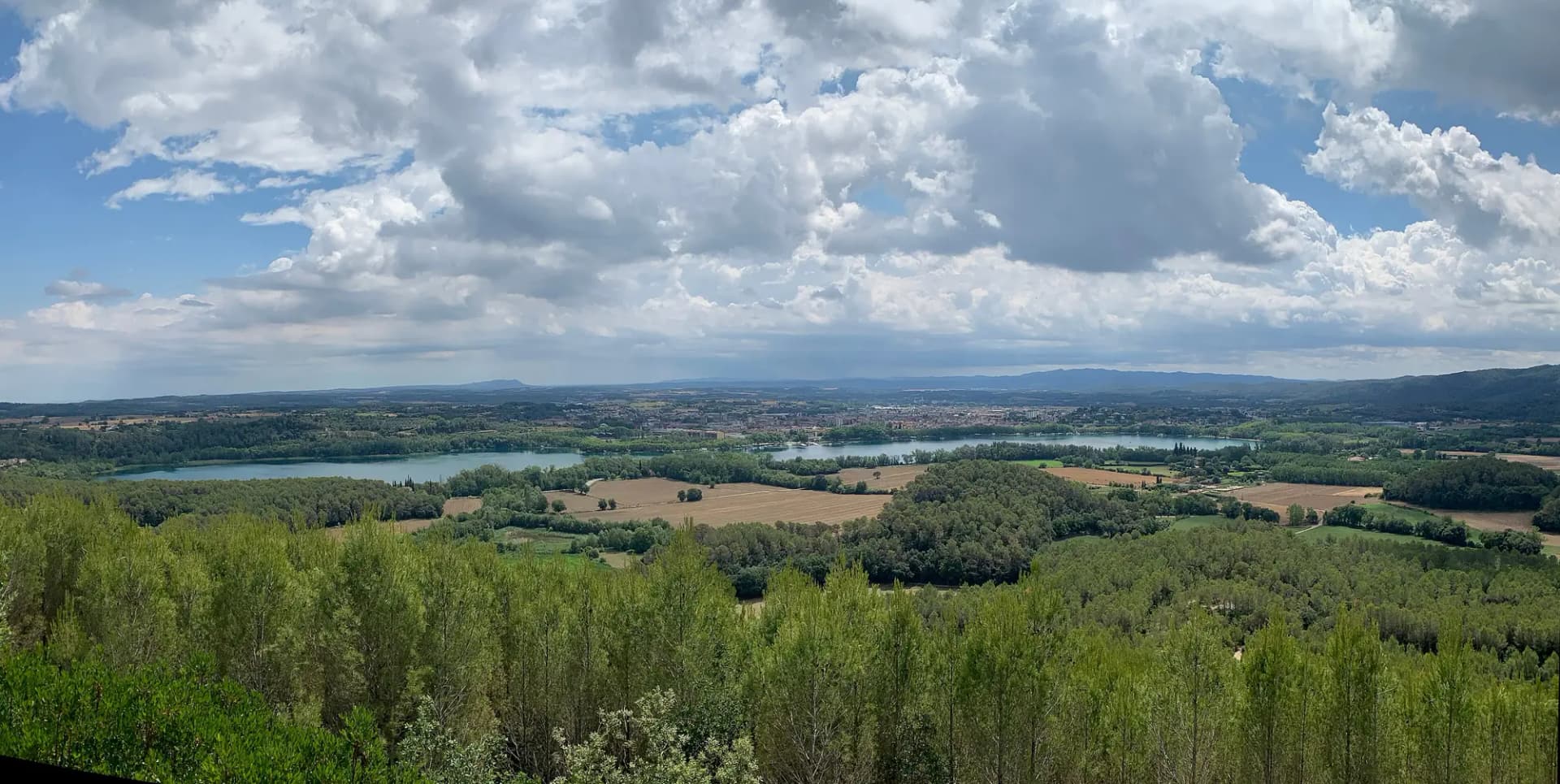 Vista del Estany de Banyoles desde el Puig Clarà, con bosque y campos alrededor