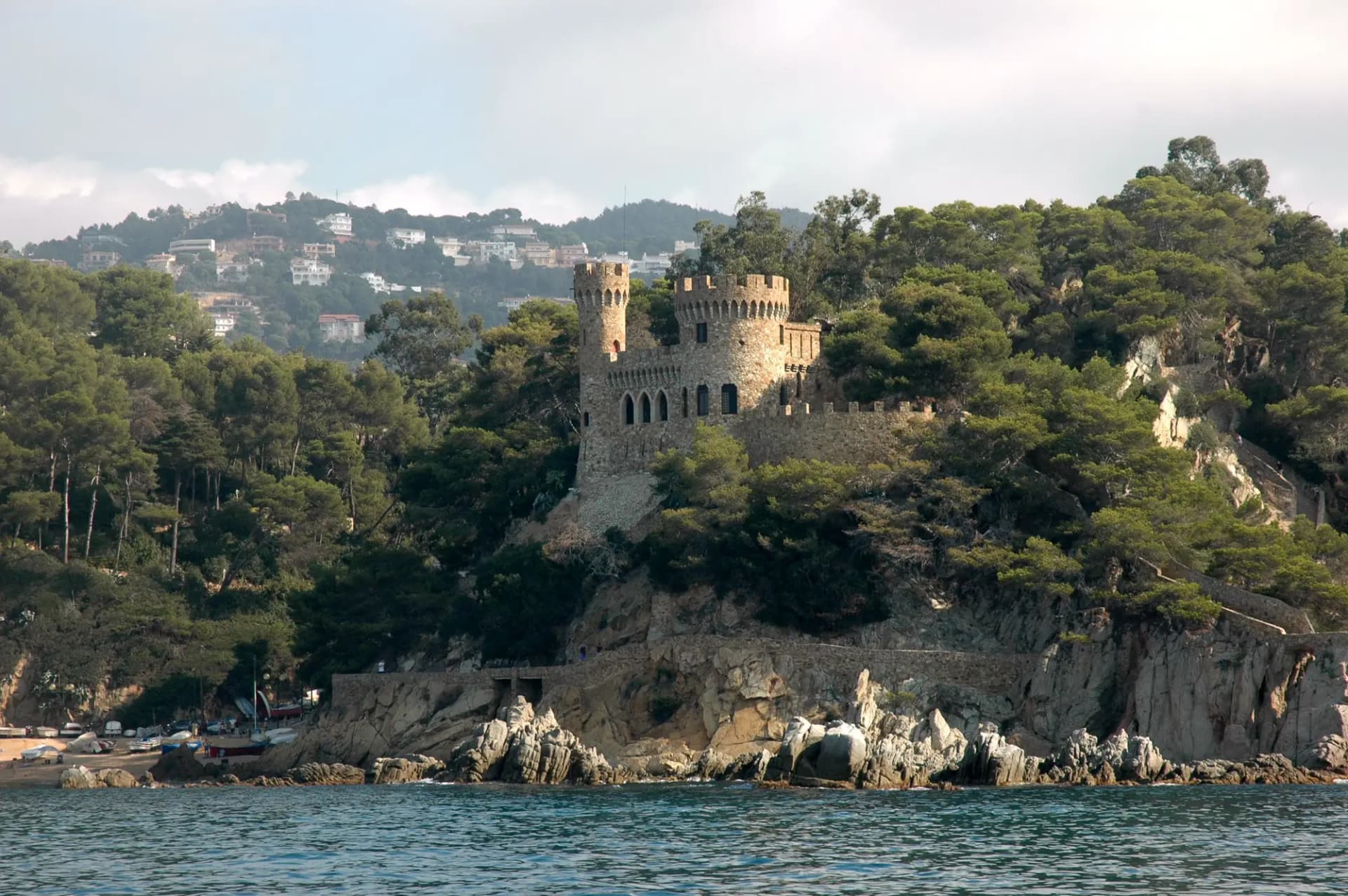 Castell d'en Plaja sobre las rocas de Lloret de Mar, rodeado de pinos junto al mar