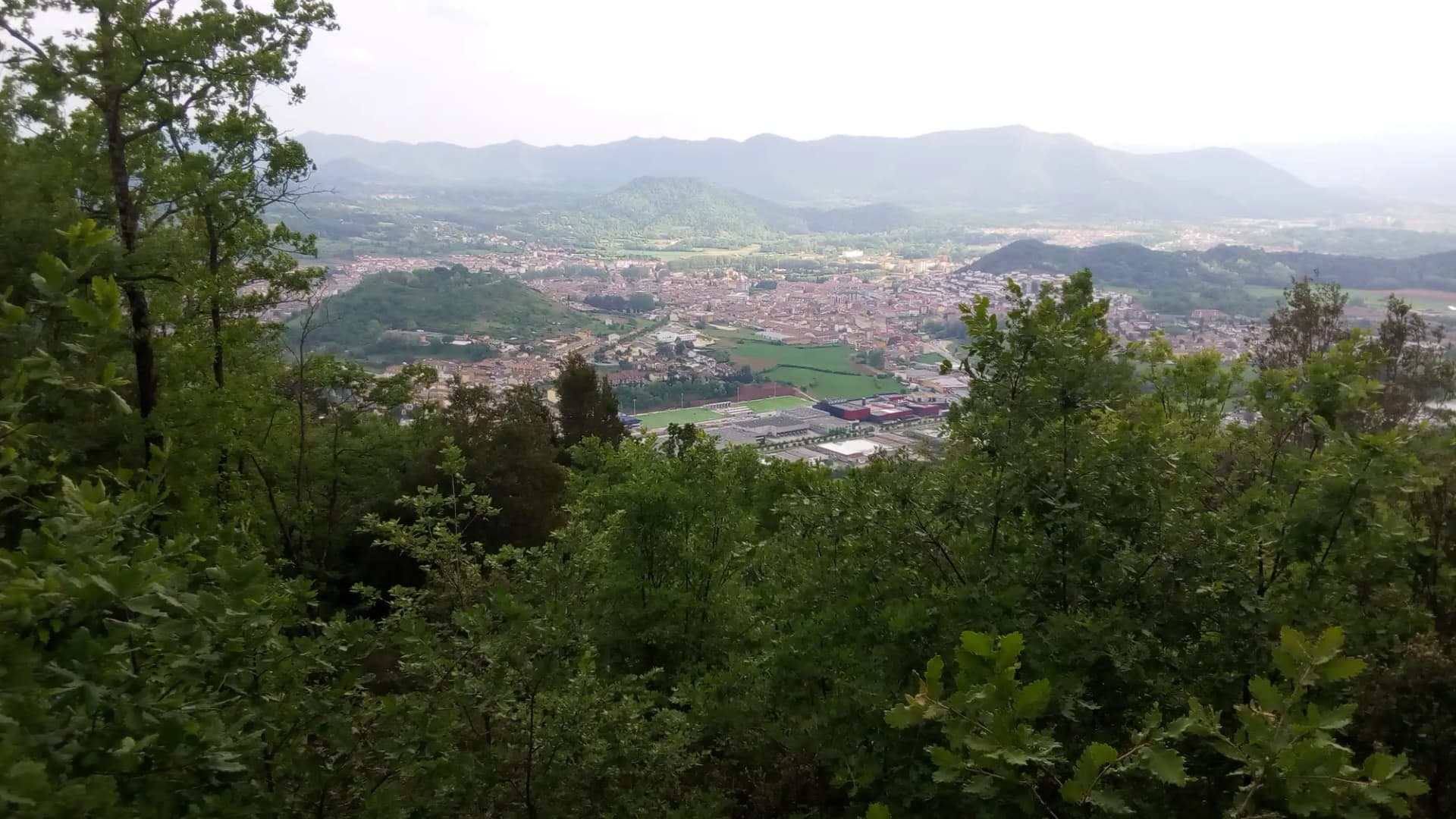 Vista de Olot en el fondo del valle, rodeada de montañas y bosques de la Garrotxa
