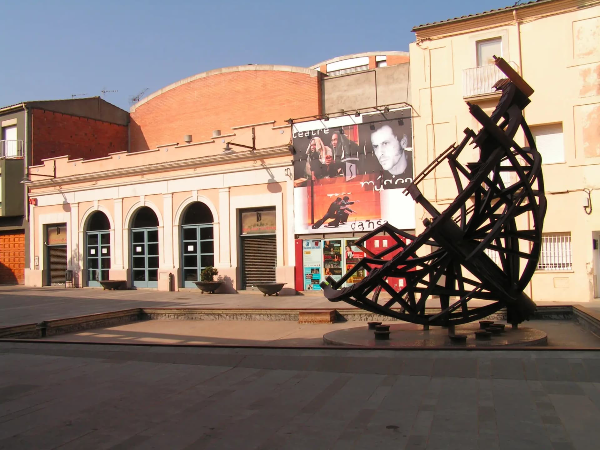 Fachada del Teatre de Salt con una escultura metálica en la plaza
