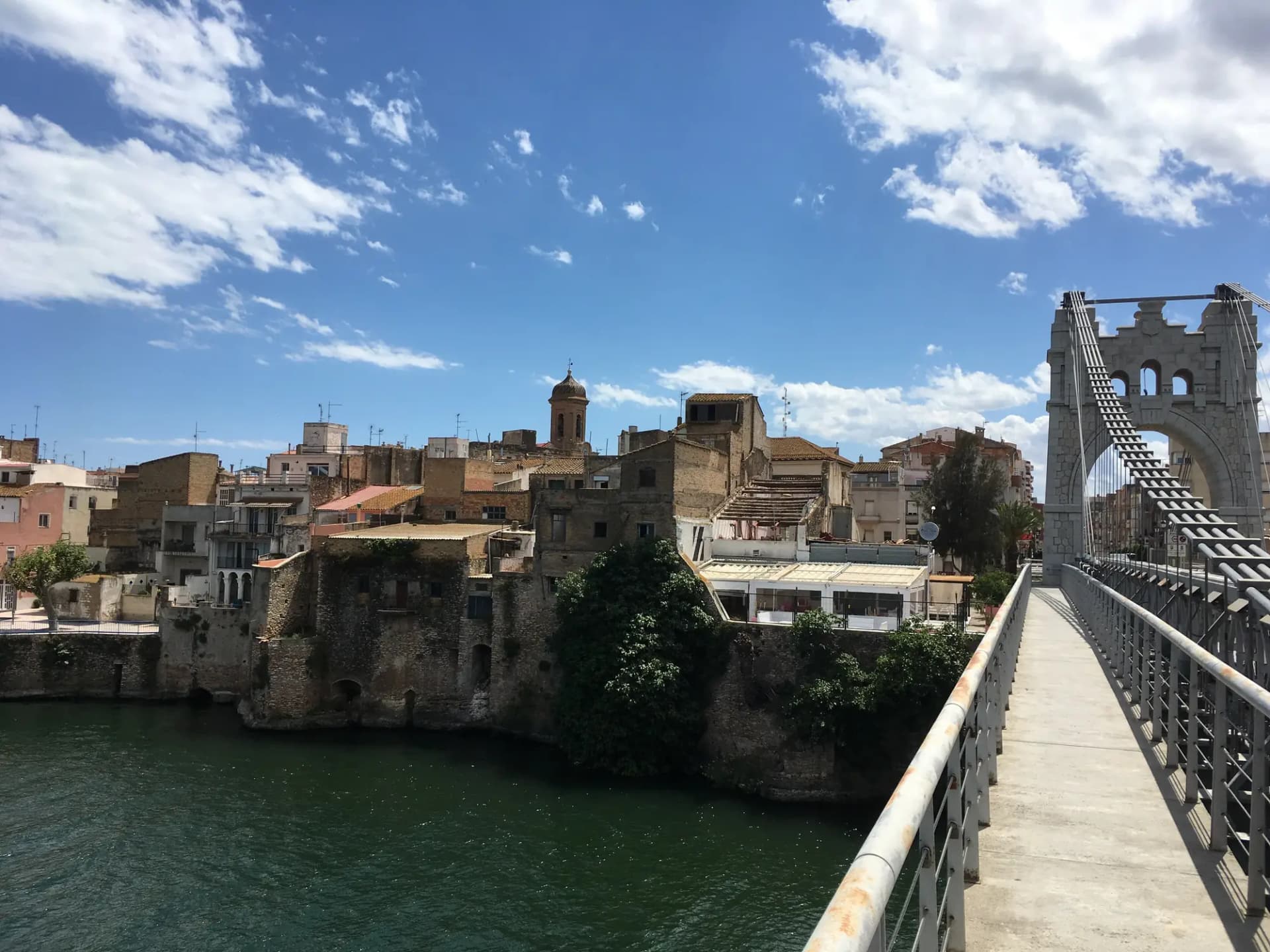 Pont Penjant de Amposta sobre el Ebro con las casas del casco antiguo al fondo