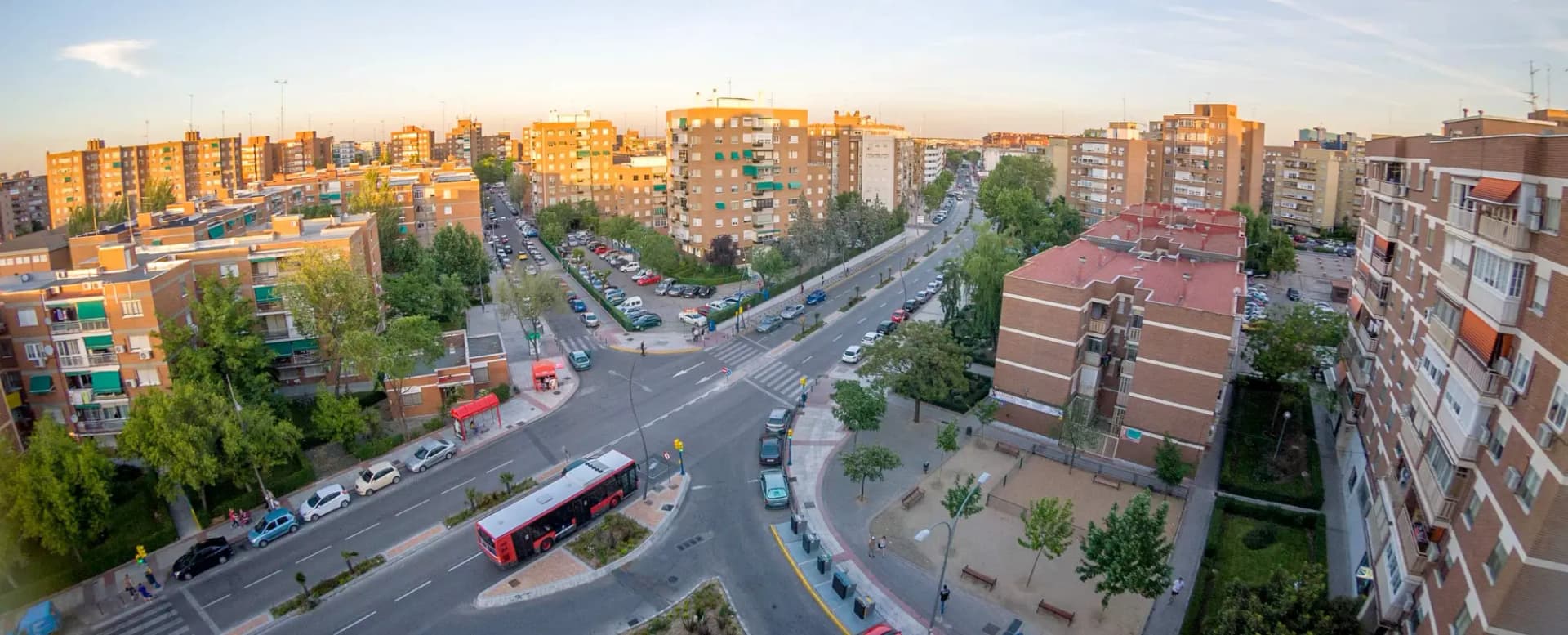 Vista elevada de una avenida de Fuenlabrada con bloques de viviendas, árboles y un autobús