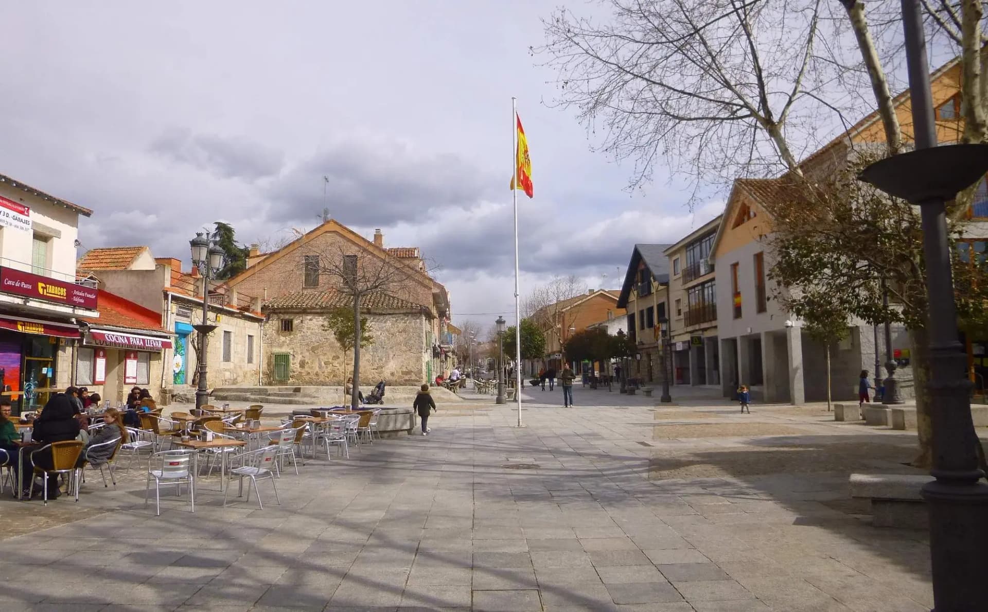 Plaza peatonal del centro de Torrelodones con terrazas y casas de piedra