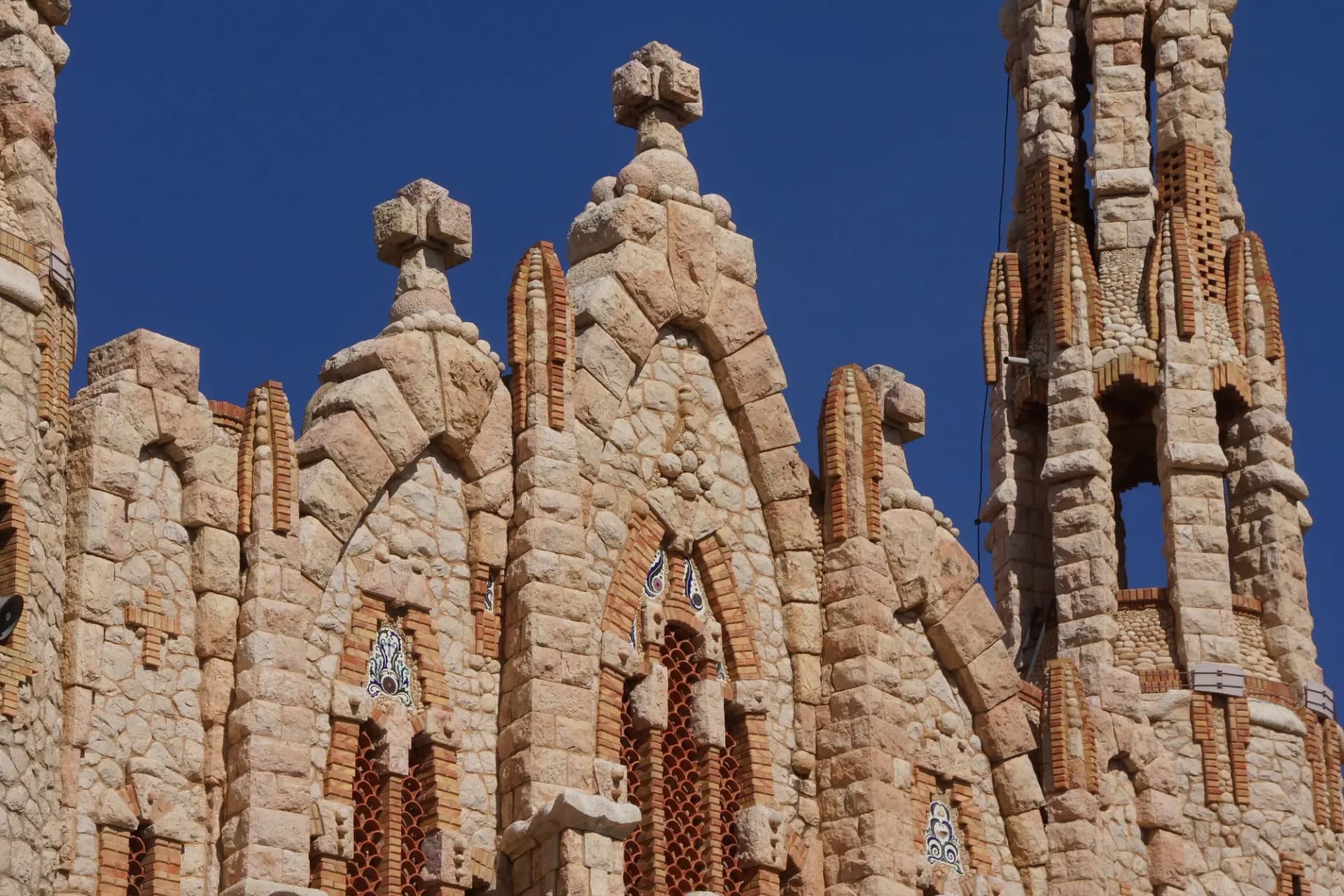 Torres modernistas de piedra del santuario de Santa María Magdalena de Novelda bajo el cielo azul