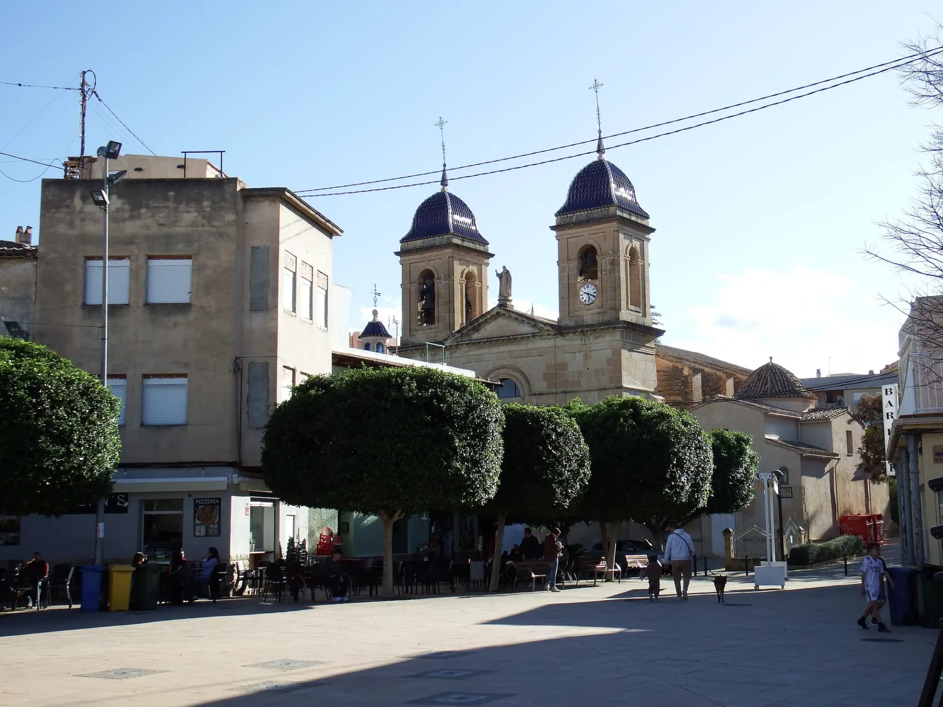 Plaza de Sant Joan d'Alacant con las dos torres de cúpula azul de la iglesia de San Juan Bautista al fondo