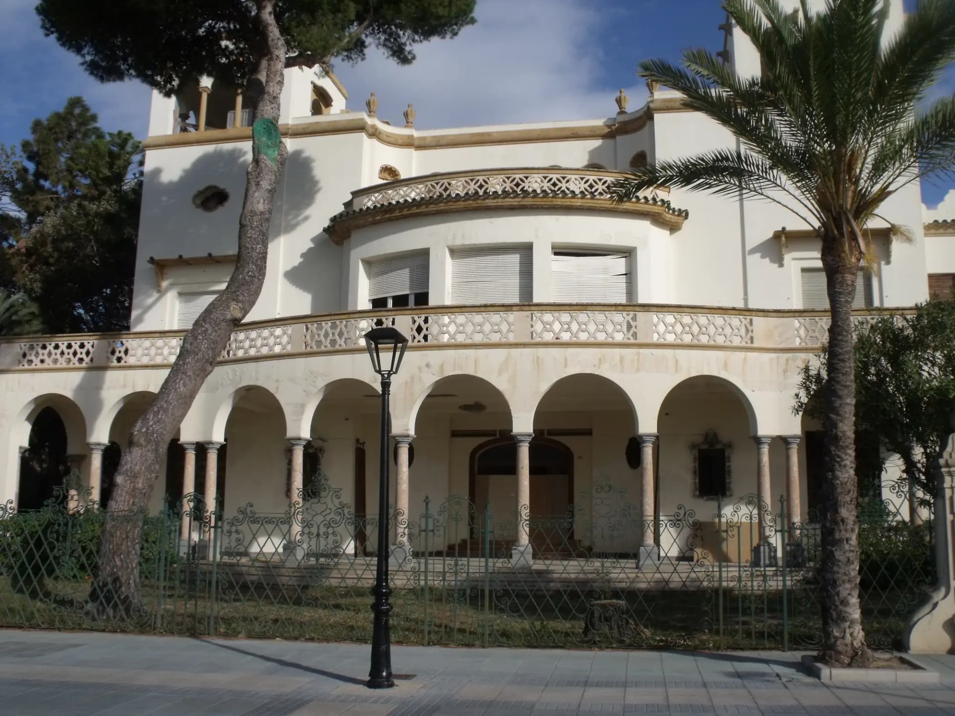 Villa modernista blanca con arcos y palmeras en el paseo marítimo de Benicàssim