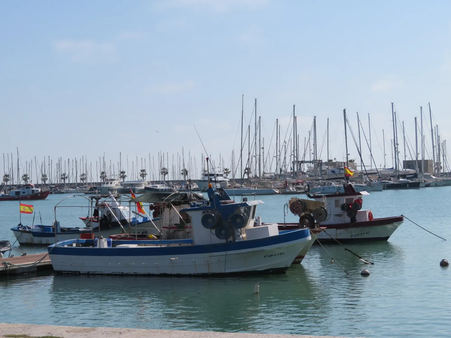 Barcas de pesca amarradas en el puerto de Borriana con los veleros del puerto deportivo al fondo