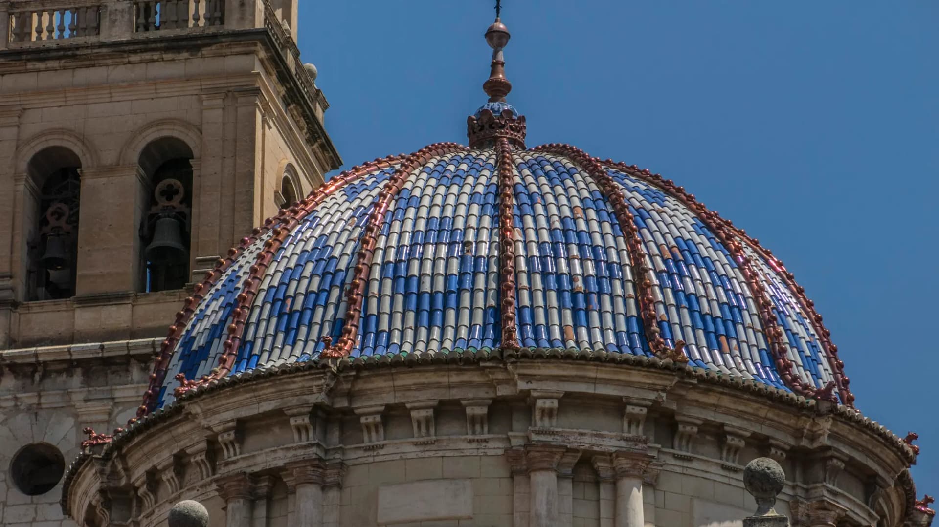 Cúpula de tejas azules y blancas de la iglesia de la Asunción de Carcaixent junto al campanario