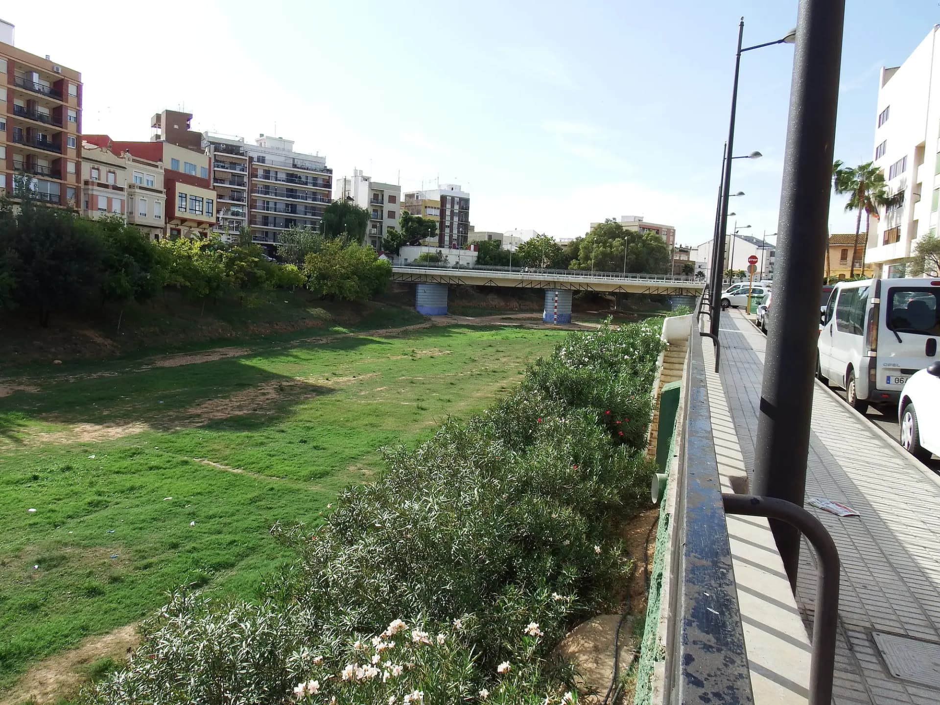 Cauce del barranco del Poyo a su paso por Paiporta, con el puente viejo y los edificios del pueblo al fondo