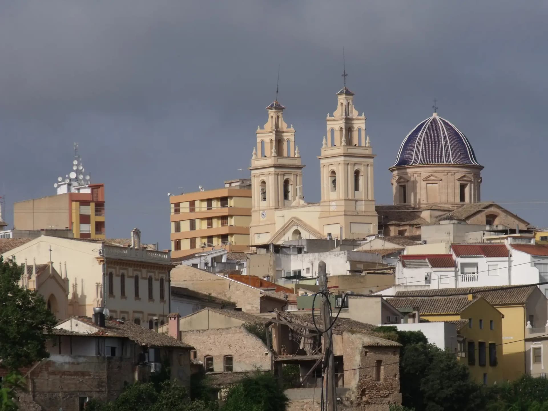 Torres y cúpula de azulejos de la iglesia de la Asunción sobre los tejados de Riba-roja de Túria