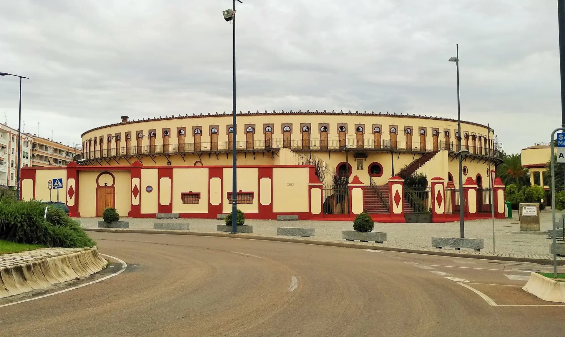 Plaza de toros neomudéjar de Almendralejo, con fachada roja y crema y galería de arcos en lo alto