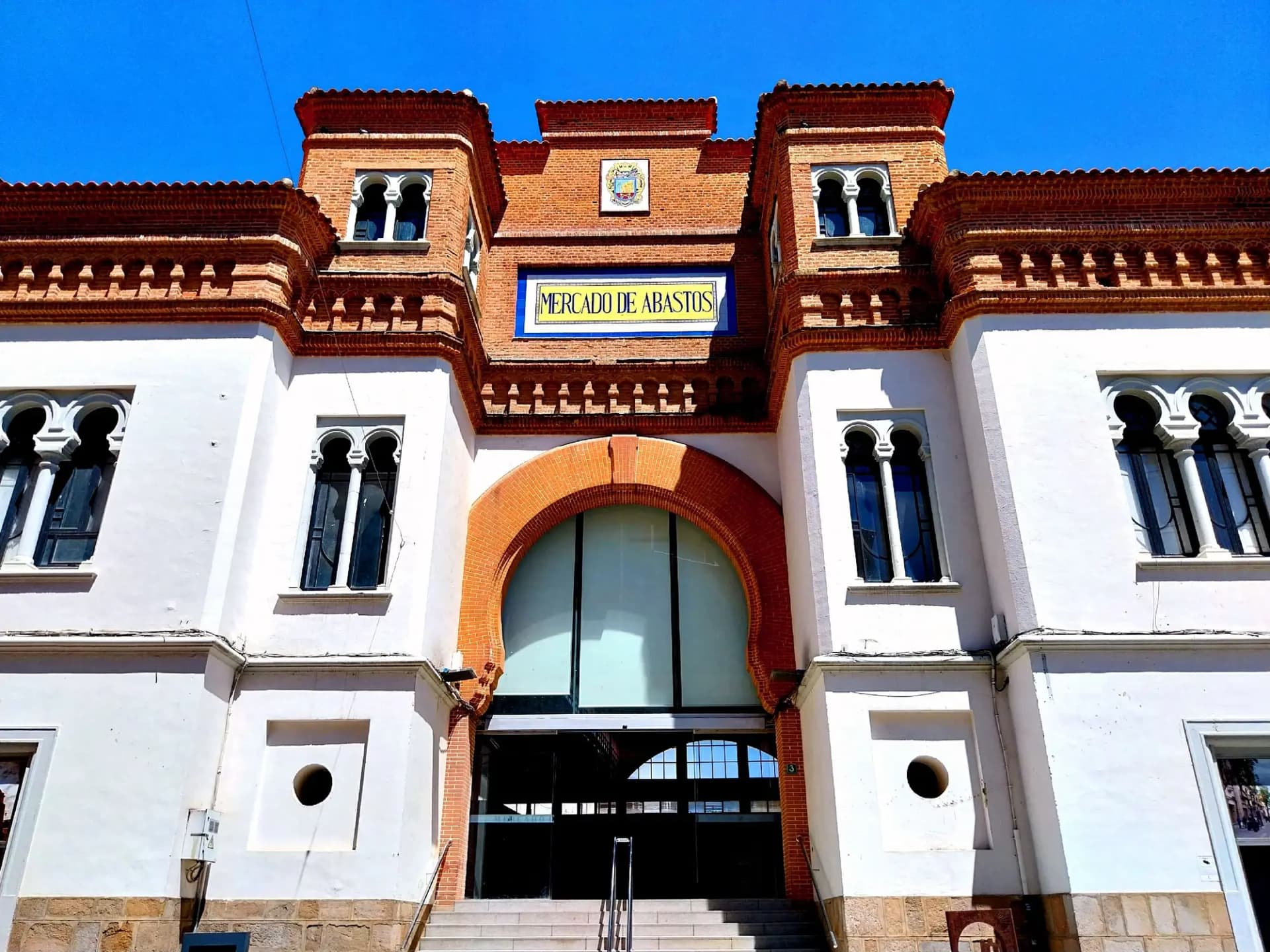 Fachada neomudéjar del Mercado de Abastos de Don Benito, en ladrillo rojo y paredes blancas
