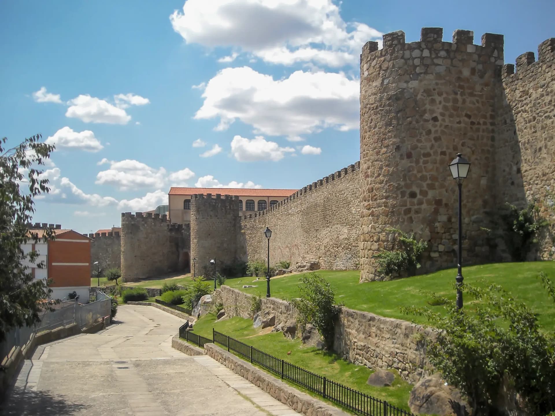 Lienzo y torreones de la muralla medieval de Plasencia junto a un paseo ajardinado
