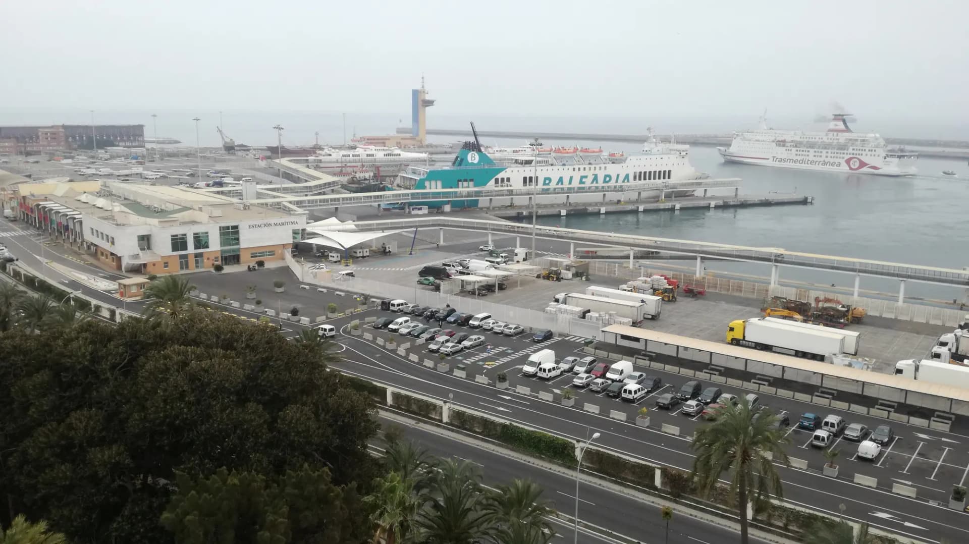 Estación marítima del puerto de Almería con un ferri atracado y otro saliendo, vista desde lo alto