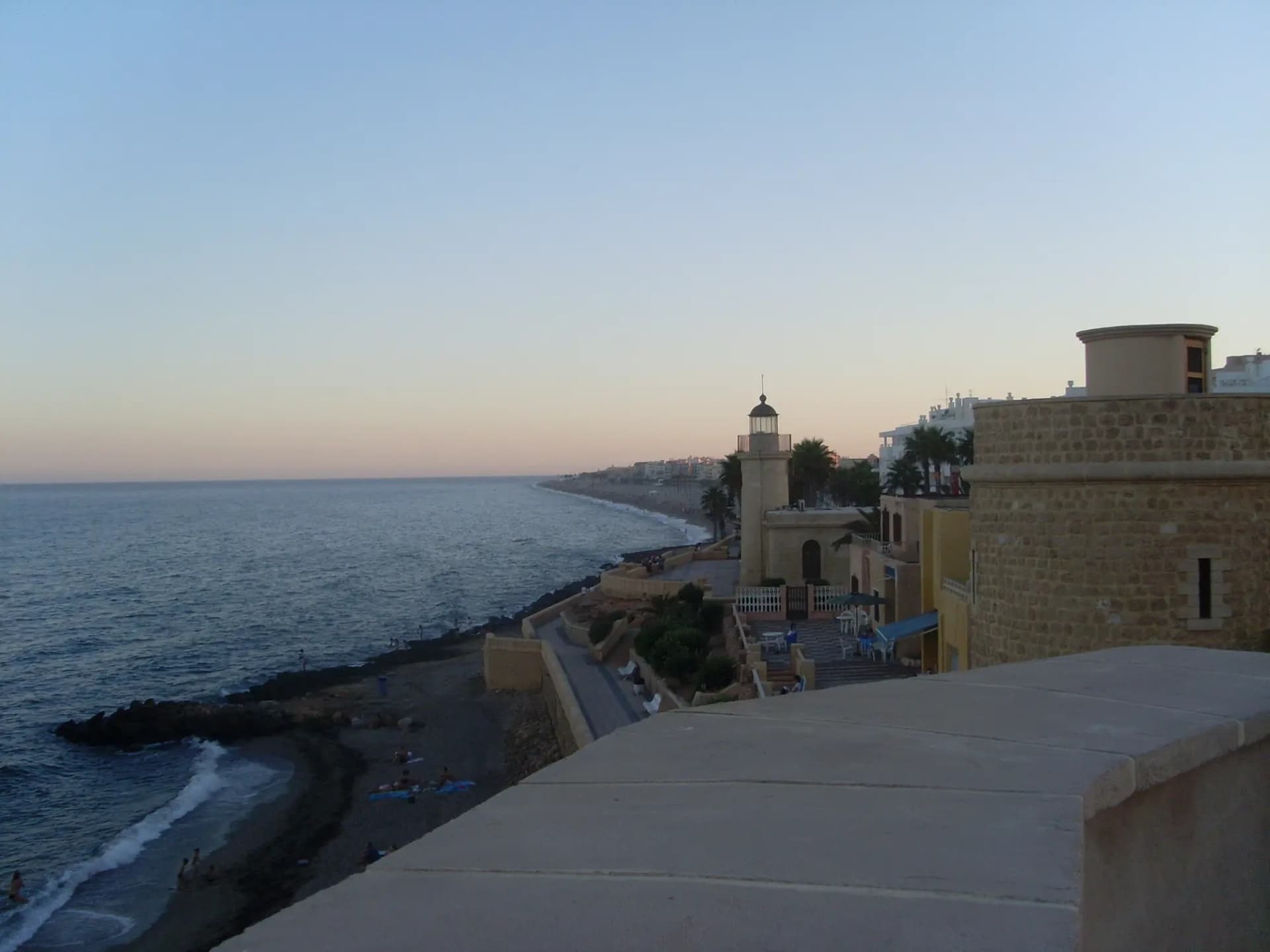 Castillo de Santa Ana y faro de Roquetas de Mar junto al mar, al atardecer