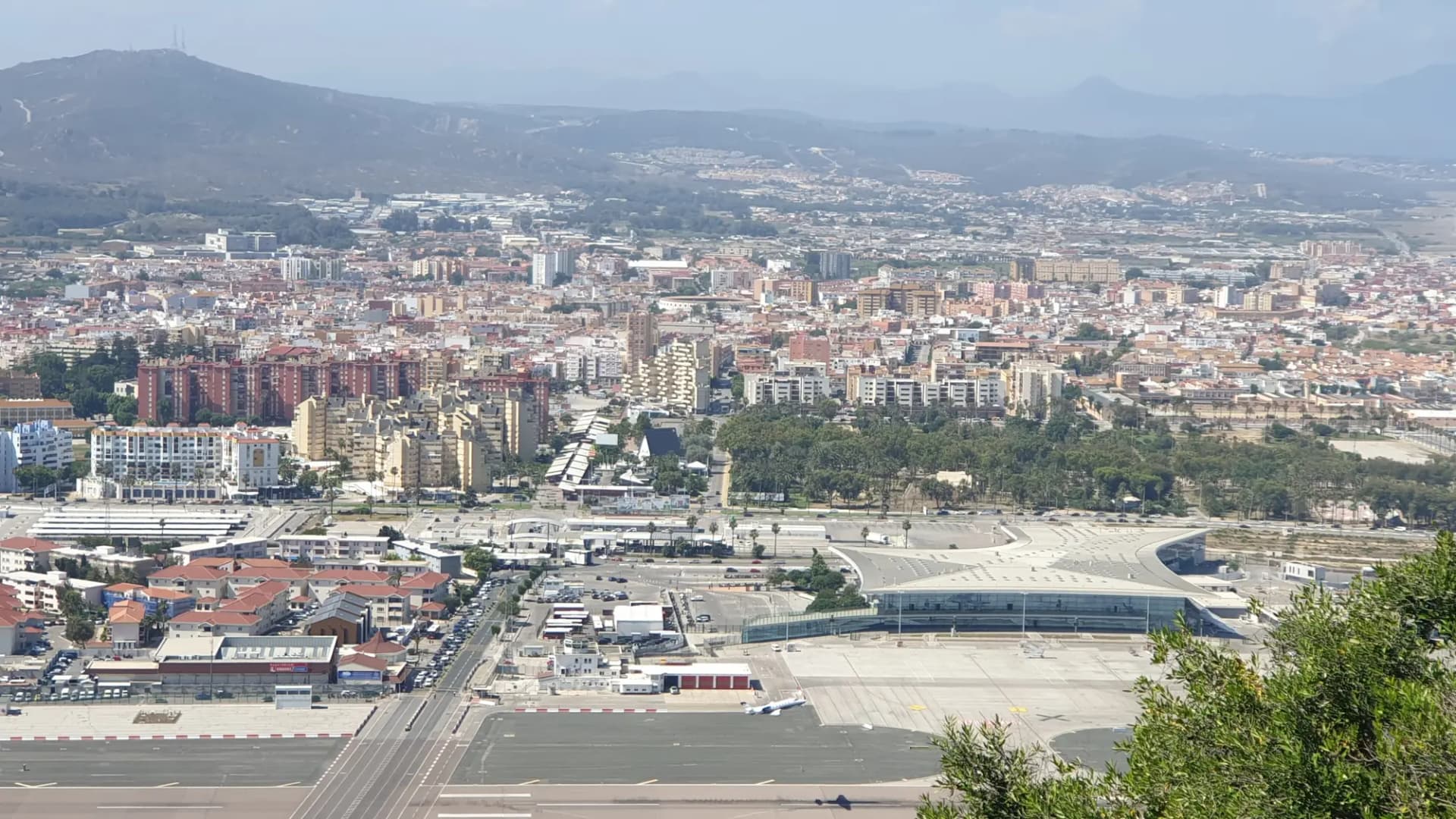 La Línea de la Concepción vista desde el Peñón, con la pista y la terminal del aeropuerto de Gibraltar en primer plano y las sierras del Campo de Gibraltar al fondo