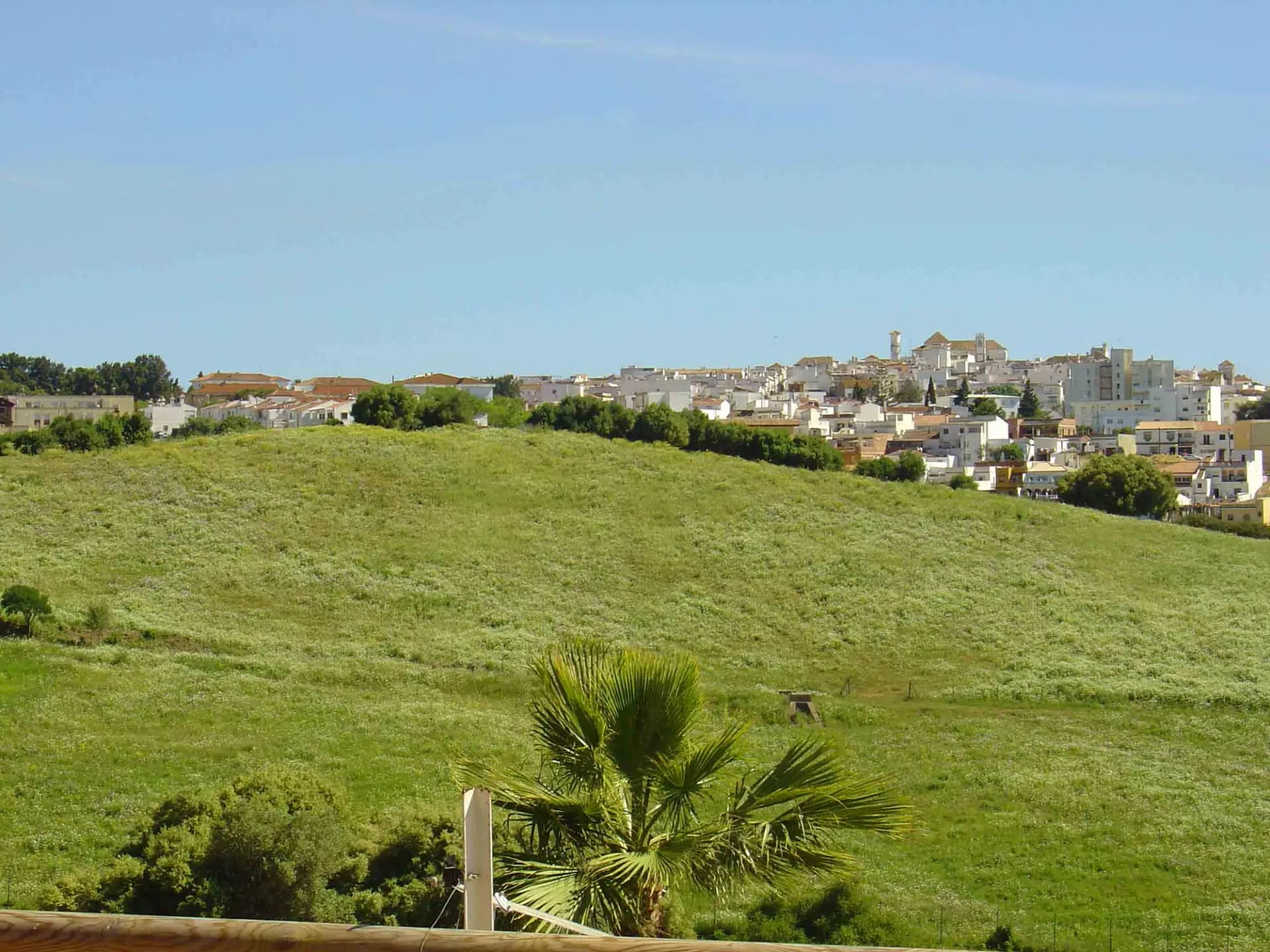 Casco de San Roque sobre una colina verde, con su iglesia en lo alto