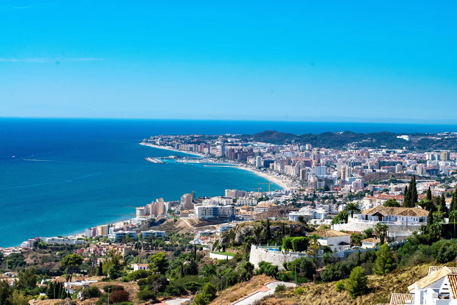 Vista desde una colina de la bahía de Fuengirola, con edificios junto a la playa y el mar azul