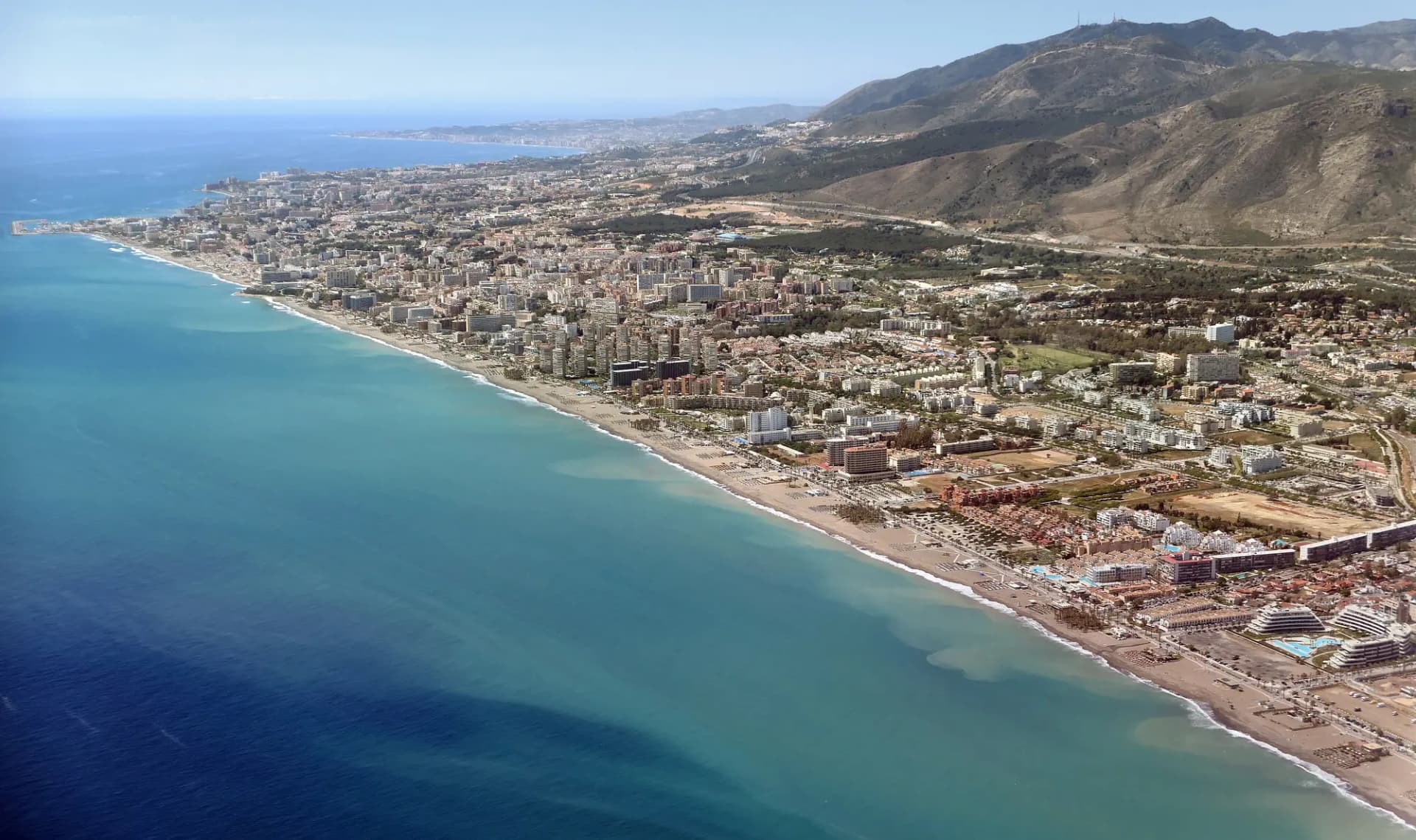 Vista aérea de la costa de Torremolinos, con playas largas, edificios junto al mar y la sierra detrás