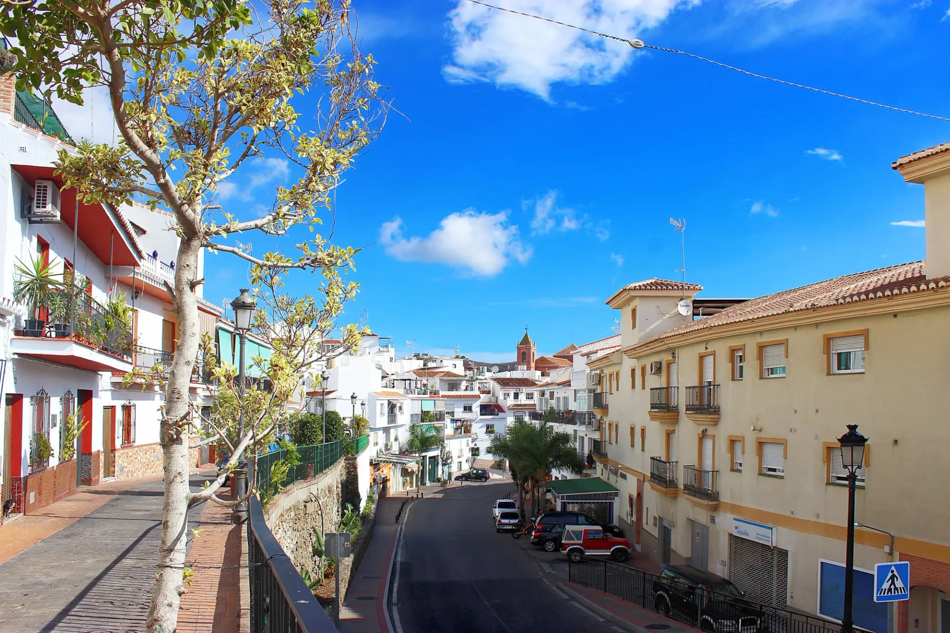 Calle de Torrox Pueblo con casas blancas y la torre de la iglesia al fondo
