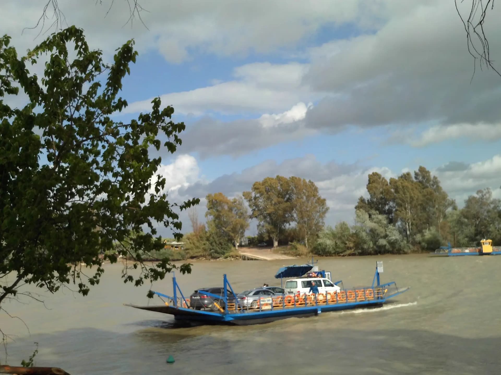La barca de Coria del Río cruzando el Guadalquivir con coches a bordo