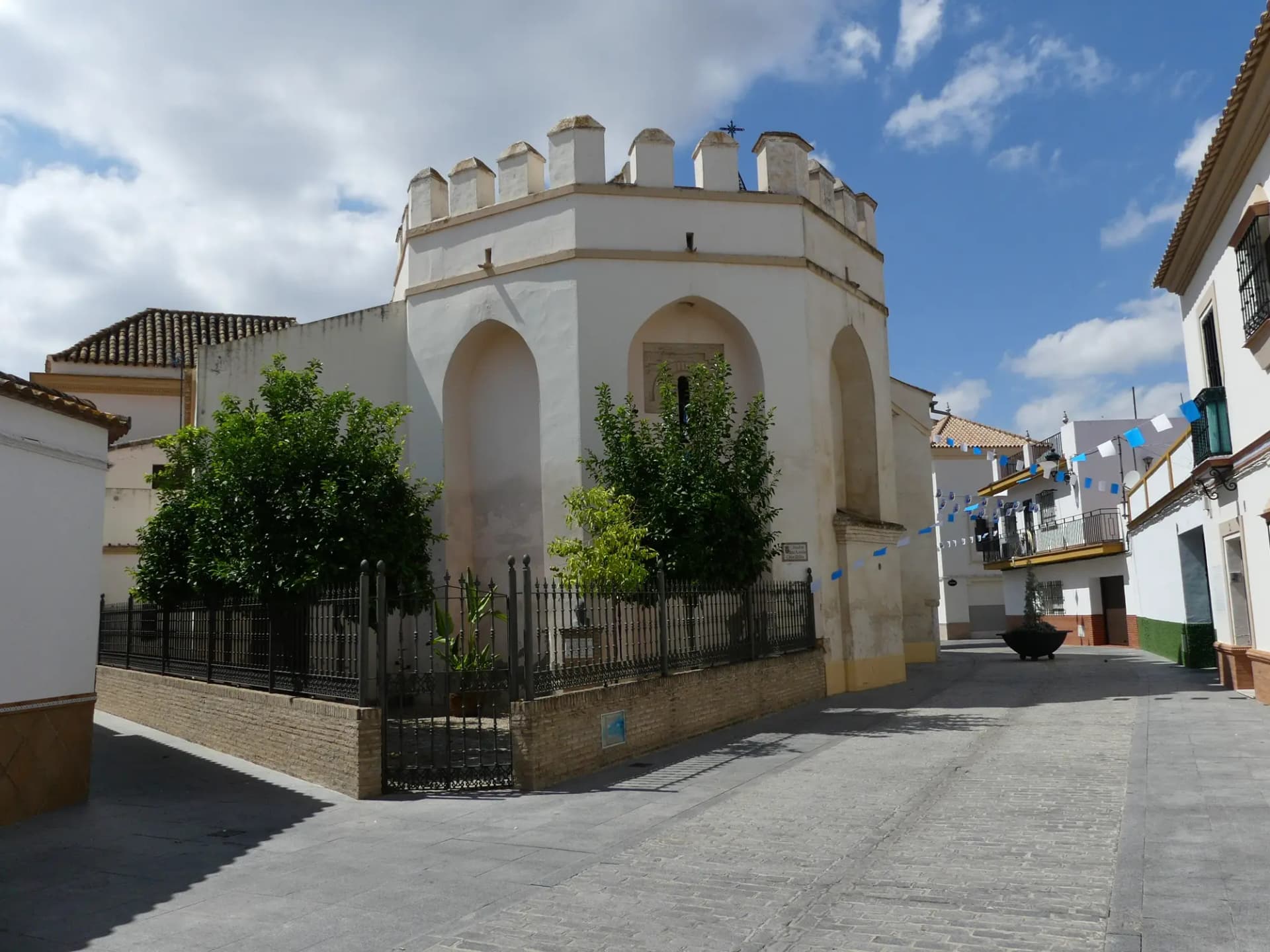 Edificio encalado con remate almenado junto a la iglesia de Nuestra Señora de las Nieves, en La Rinconada