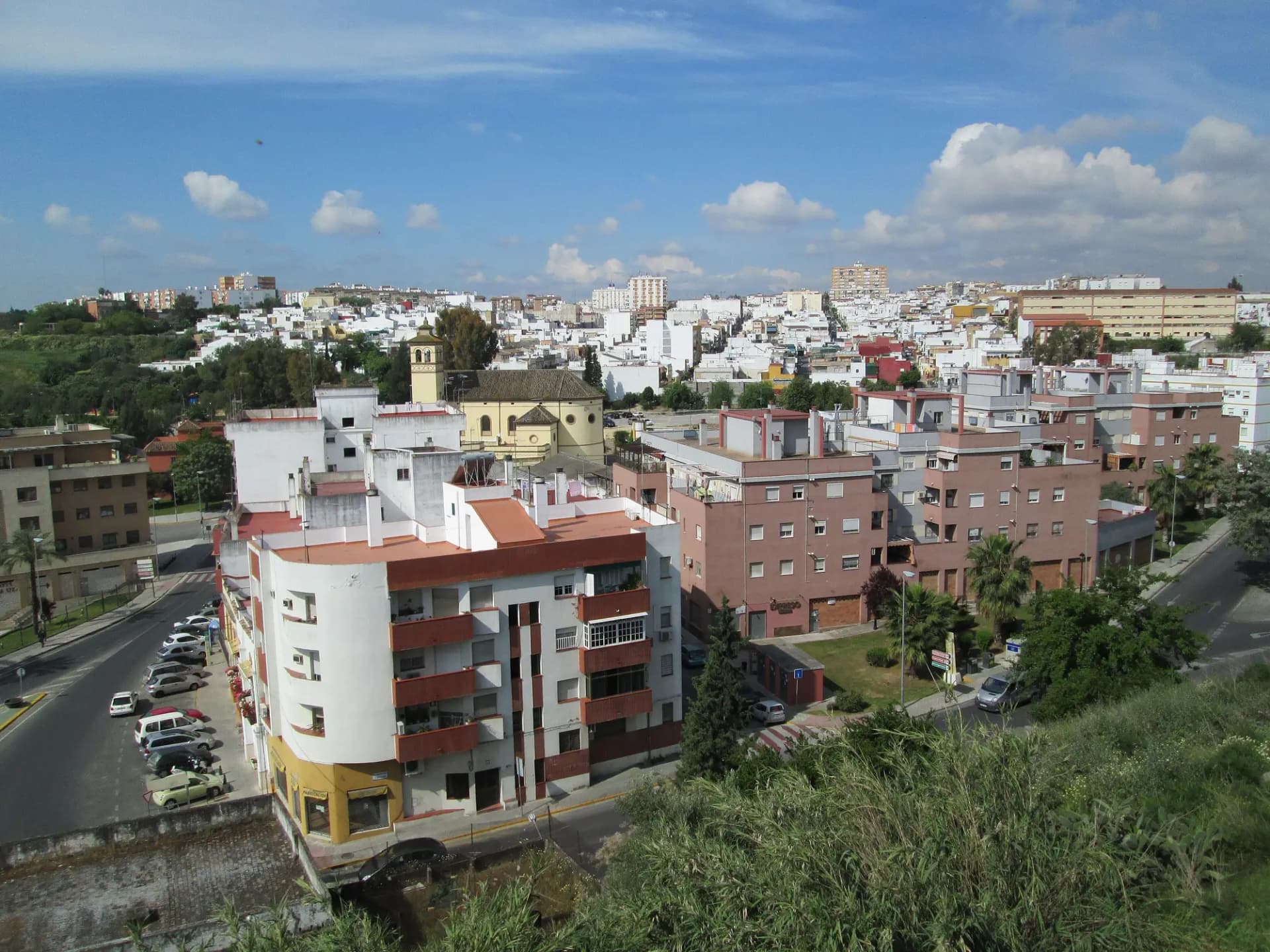 Vista de San Juan de Aznalfarache desde lo alto, con bloques de viviendas y el caserío del Aljarafe al fondo