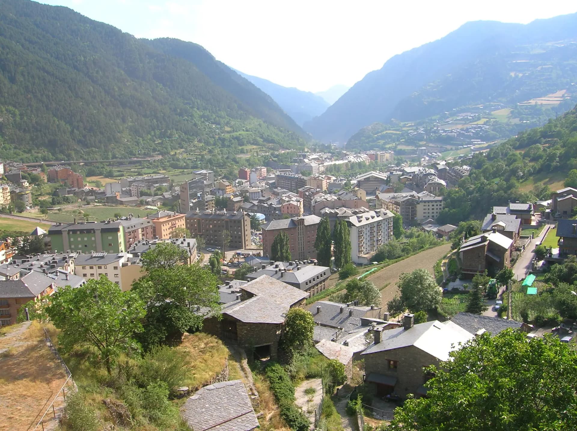 Vista del núcleo urbano de Encamp, con casas de piedra en primer plano y el valle de la Valira d'Orient al fondo
