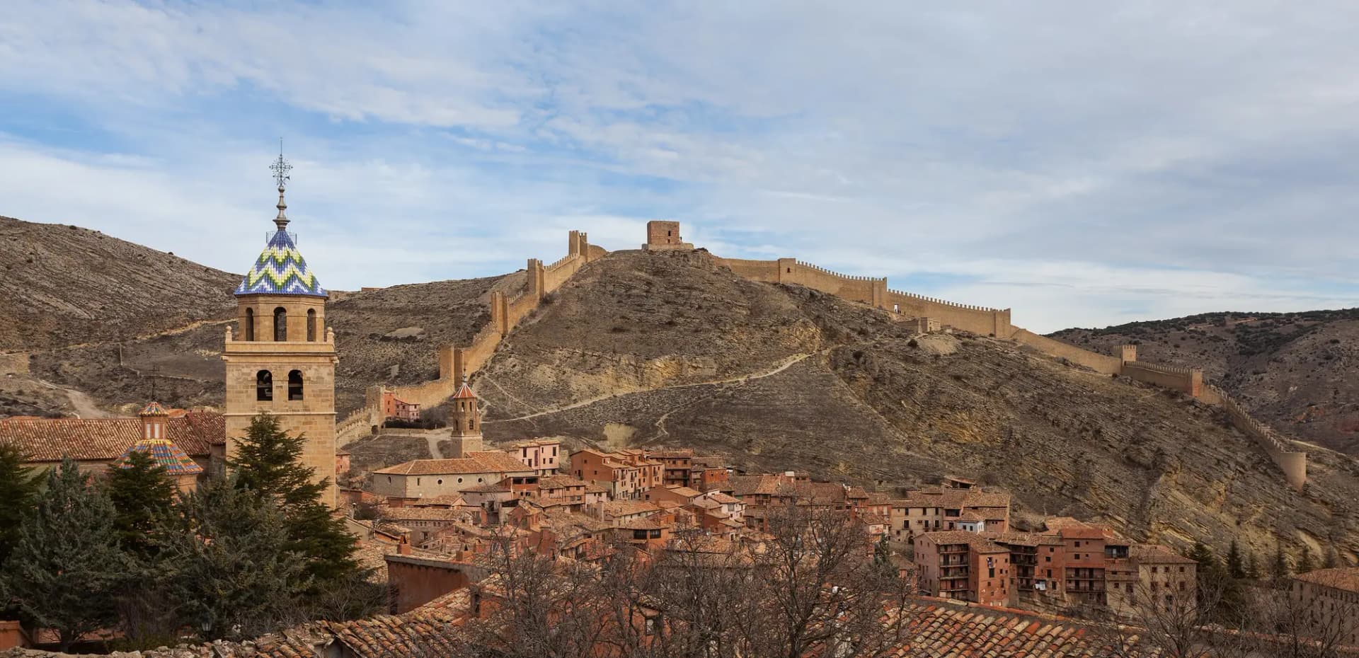 Casas de Albarracín con la torre de la catedral y la muralla subiendo por el cerro