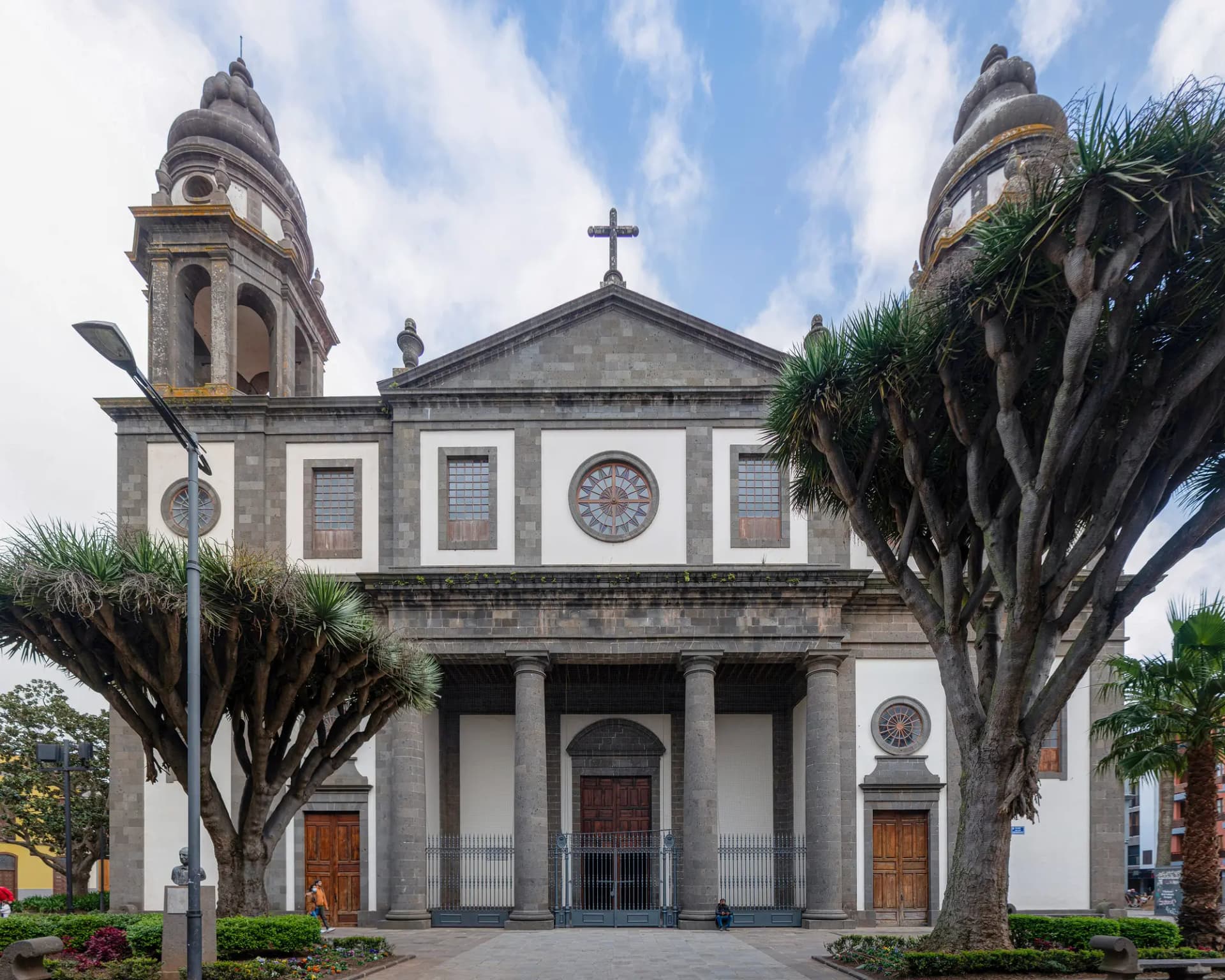 Fachada neoclásica de la catedral de La Laguna, con dos torres, flanqueada por dragos